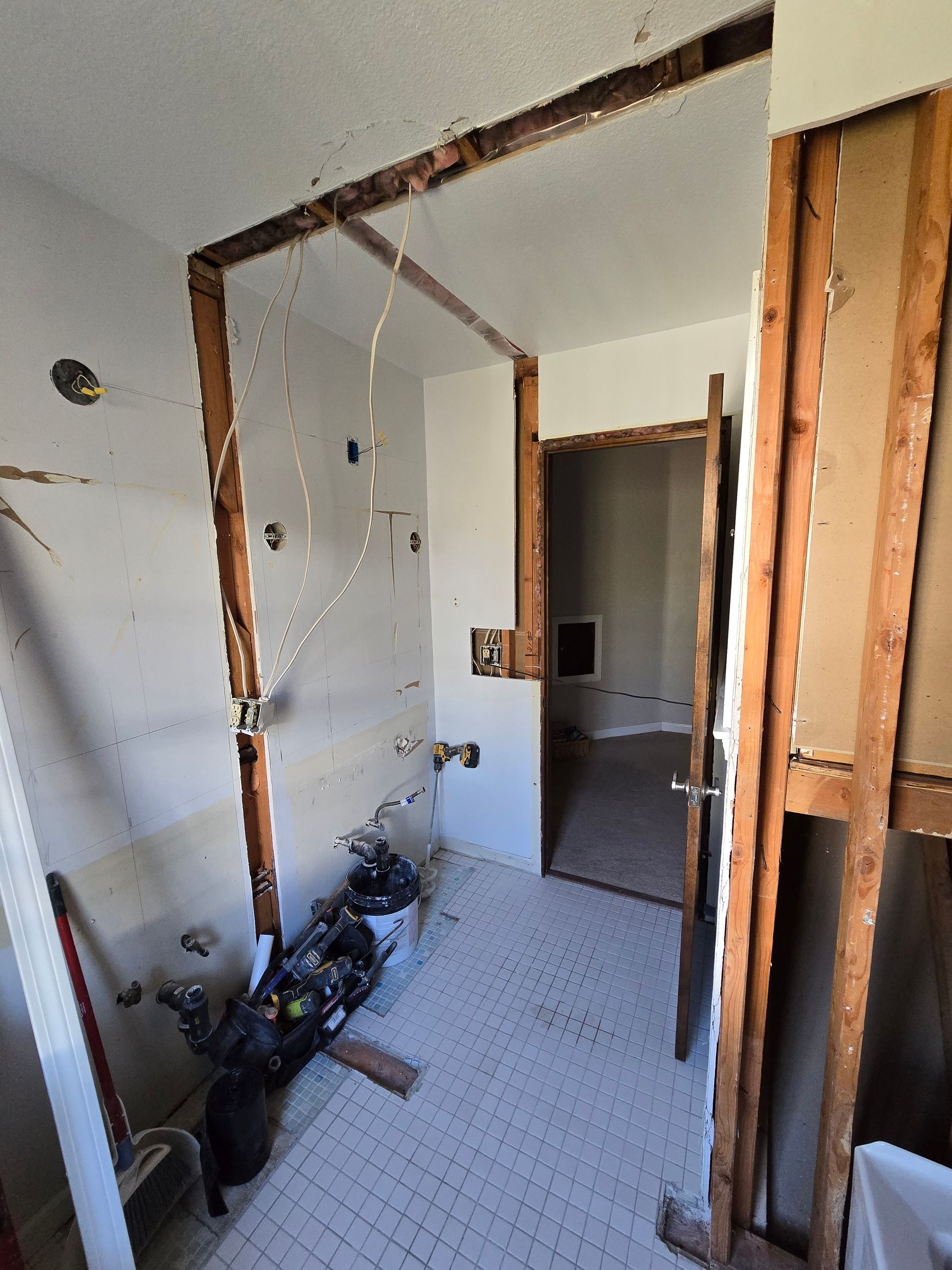 A bathroom that is being remodeled with a broken wall