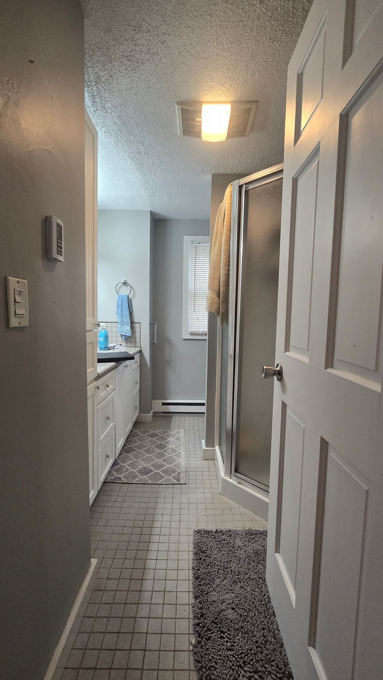 A bathroom with yellow walls , a sink , a mirror and a window.