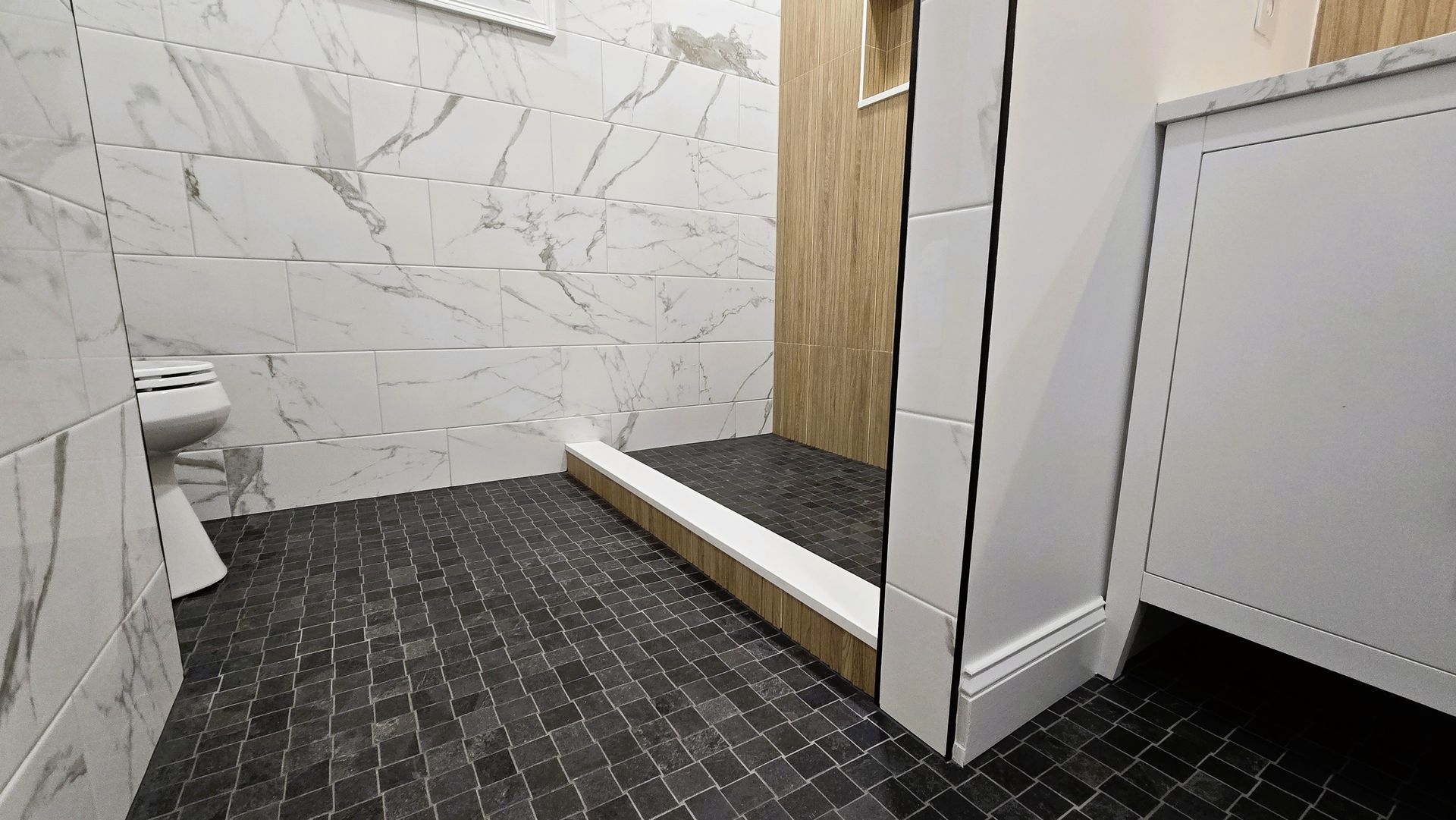 A bathroom with a walk in shower , sink , and mirror.