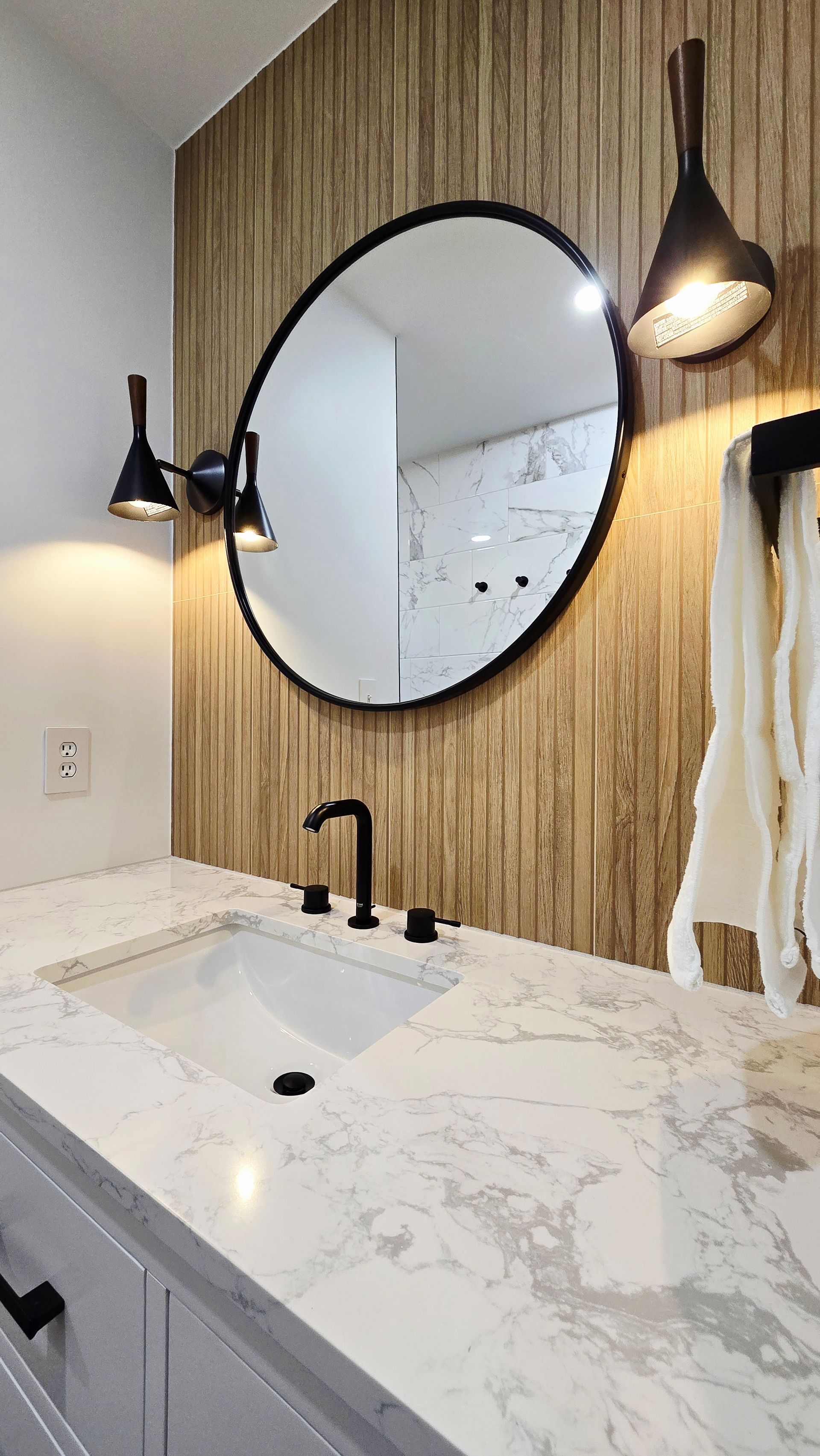 A bathroom with a sink , mirror and towel rack.