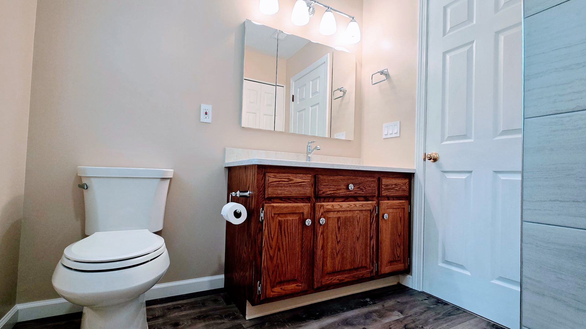 A bathroom with a walk in shower with a wooden wall and marble tiles.