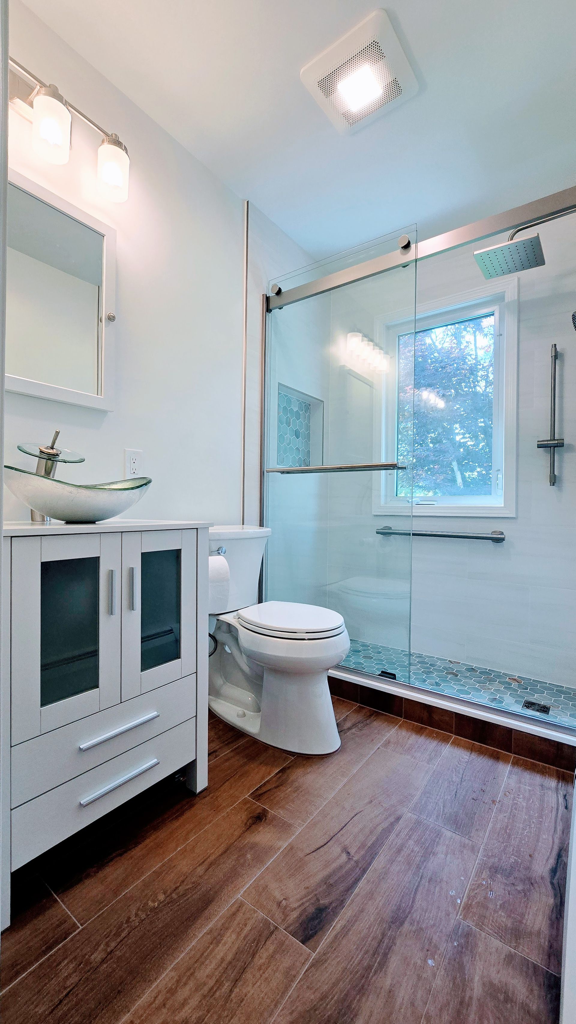 A bathroom with a tub , toilet , sink and mirror.