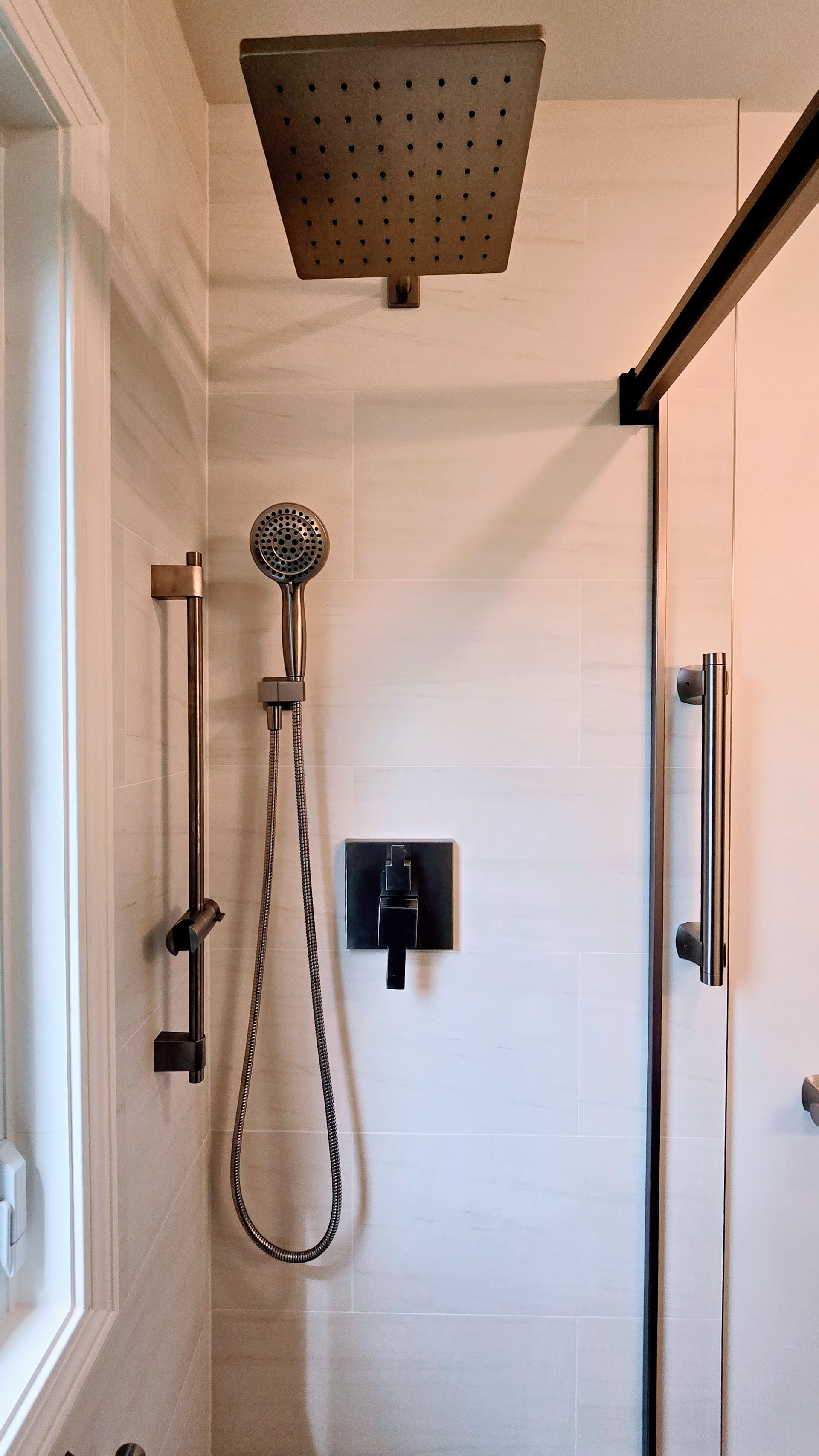 A shower with a built in shelf and a shower head