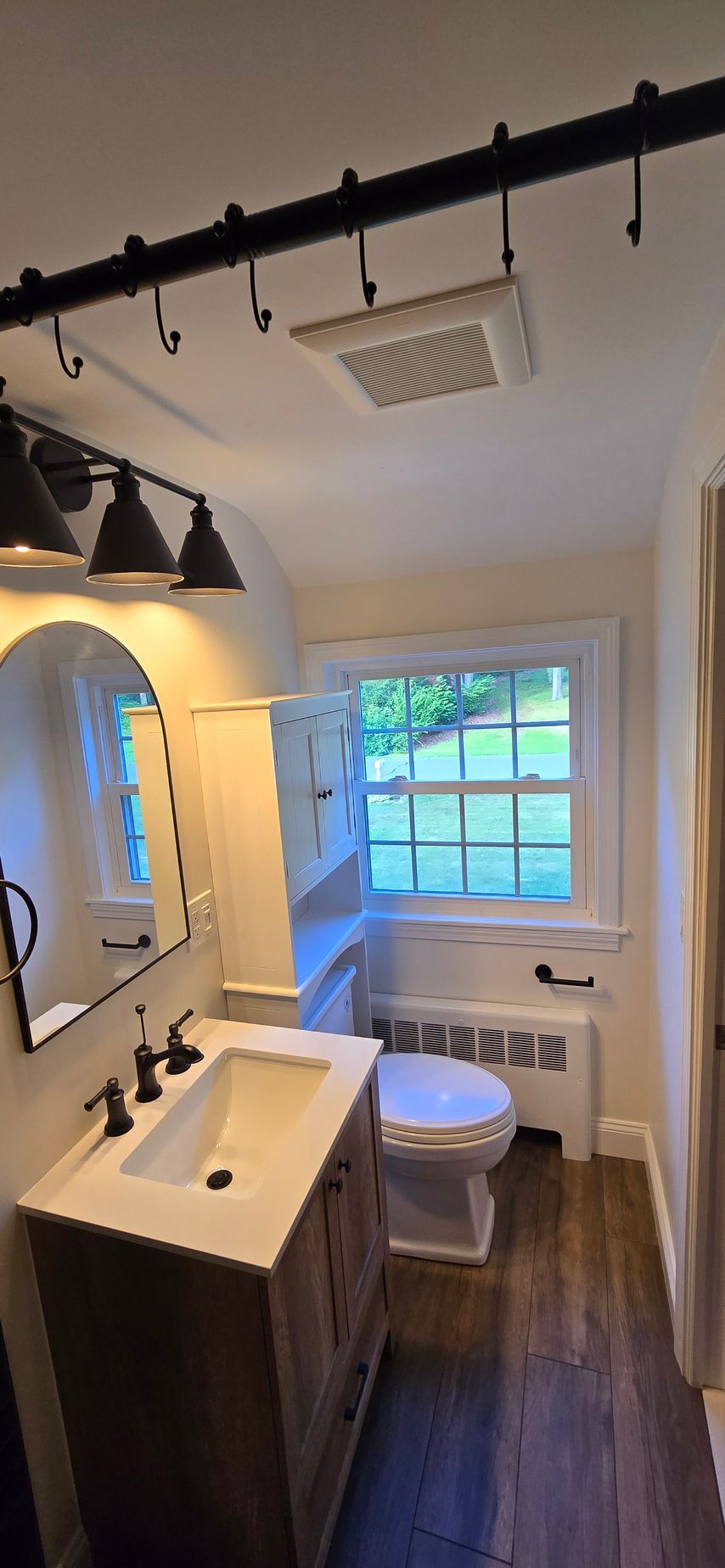 A walk in shower with a bench and a shower head.