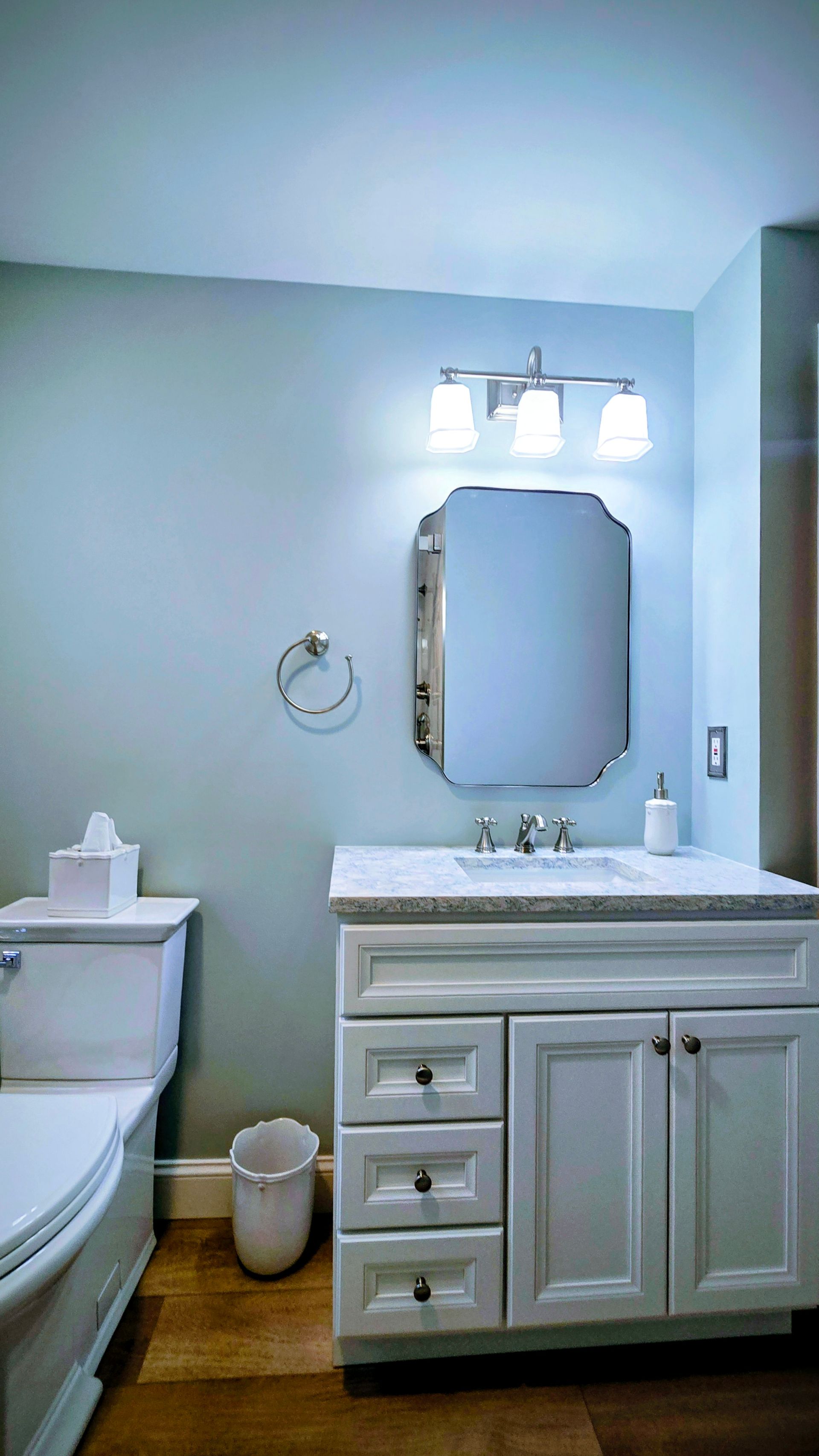 Bathroom with white vanity, mirror, toilet, and light blue walls in Bristol, CT