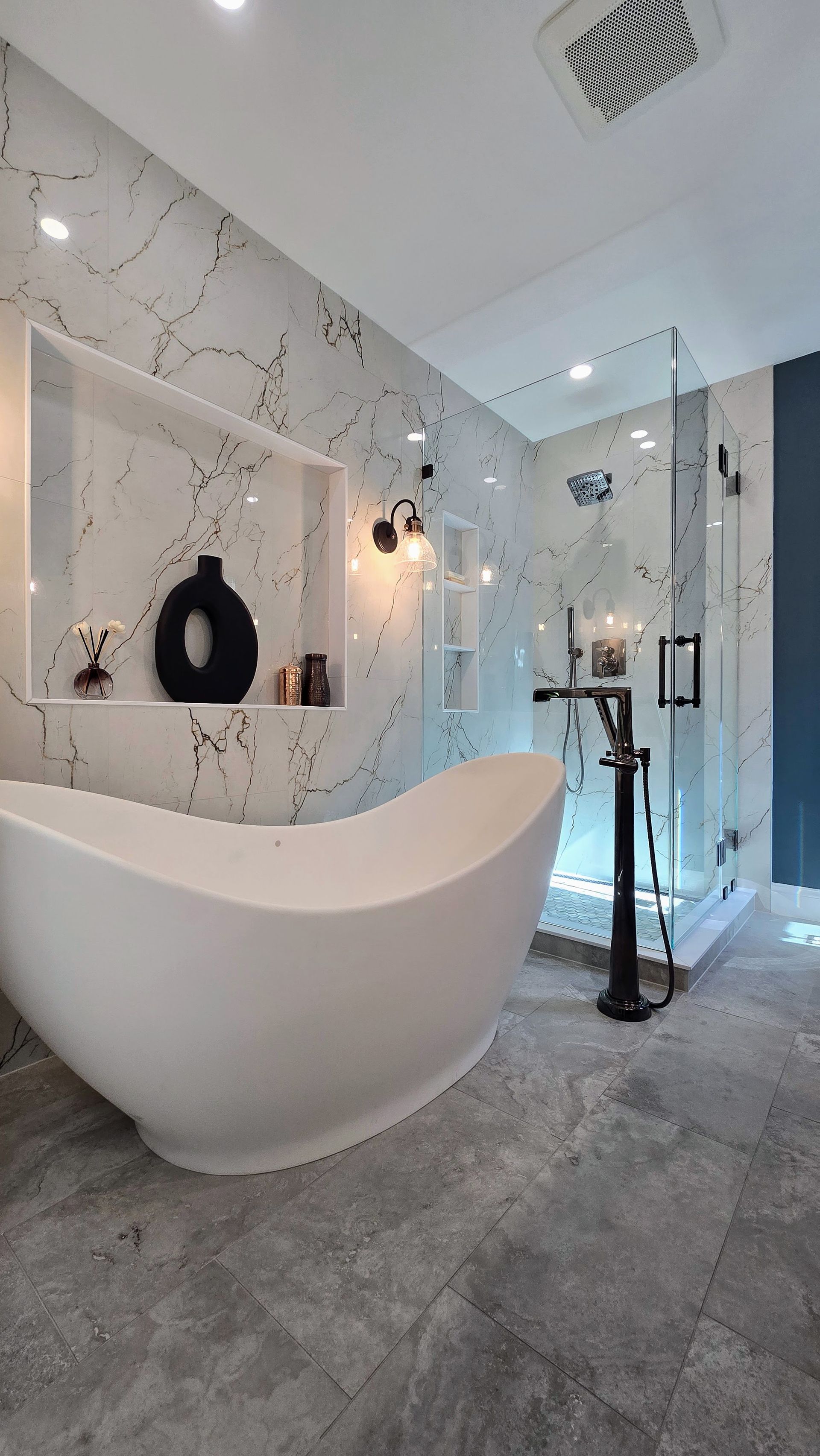 A bathroom with a walk in shower with a glass door.
