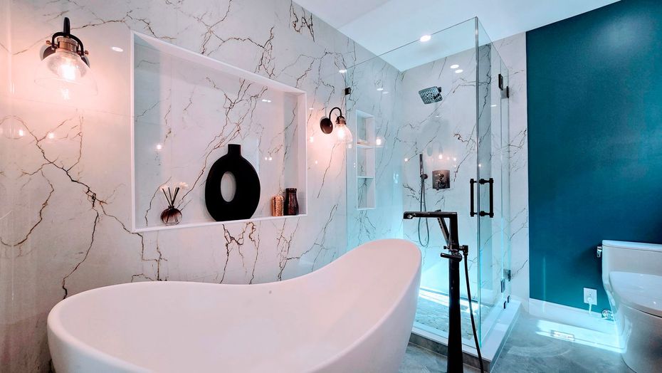 Modern bathroom remodel in Avon, CT with a white bathtub, glass shower, teal accent wall, and marble-like walls.