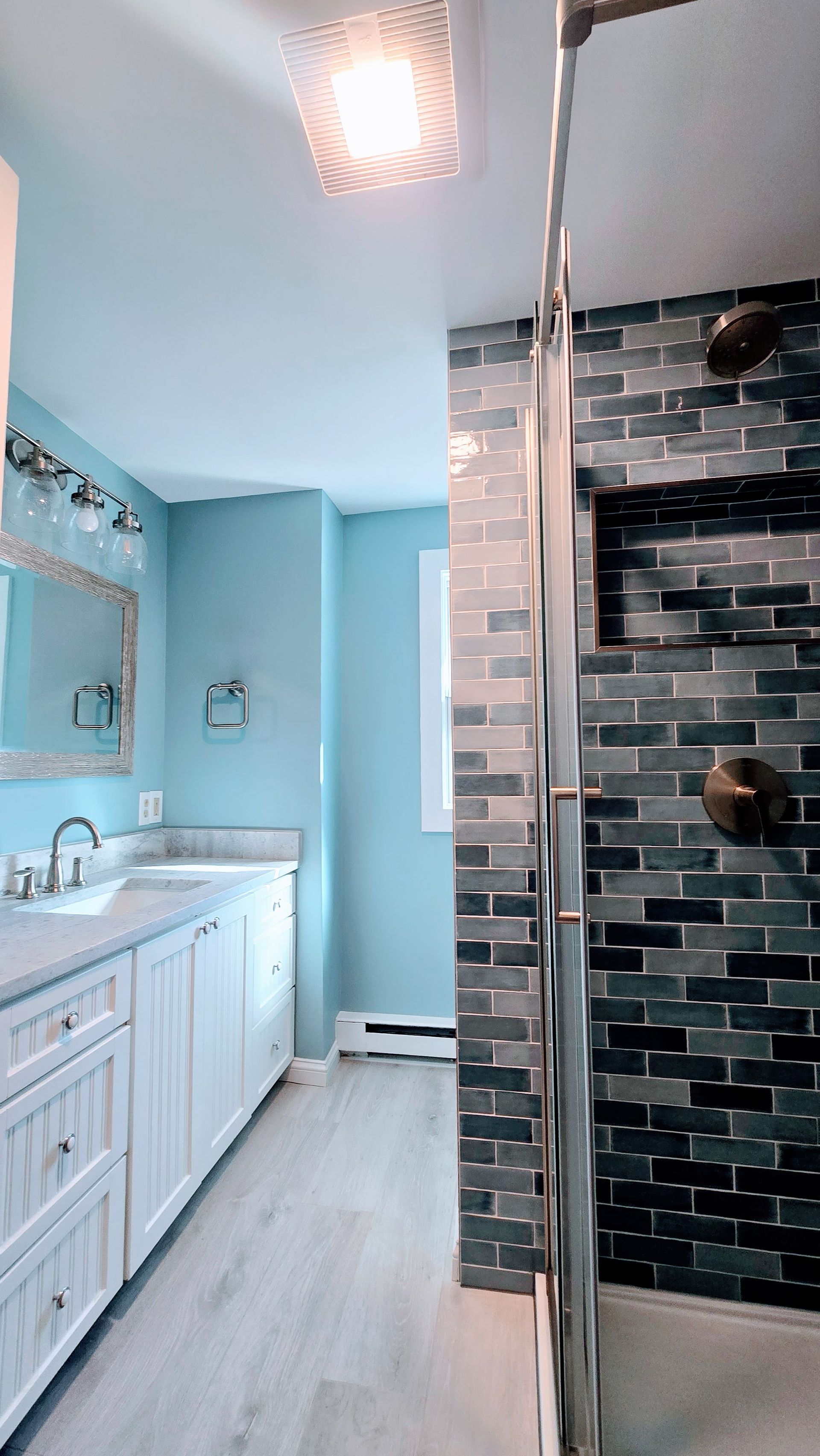 A bathroom with a bathtub , sink , mirror and shower.