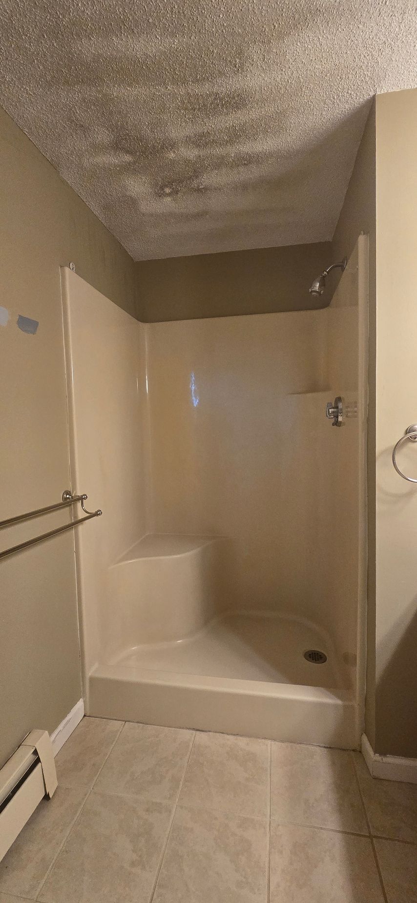 Bristol Bathroom with double sinks, lit mirror, wooden cabinets, and window.