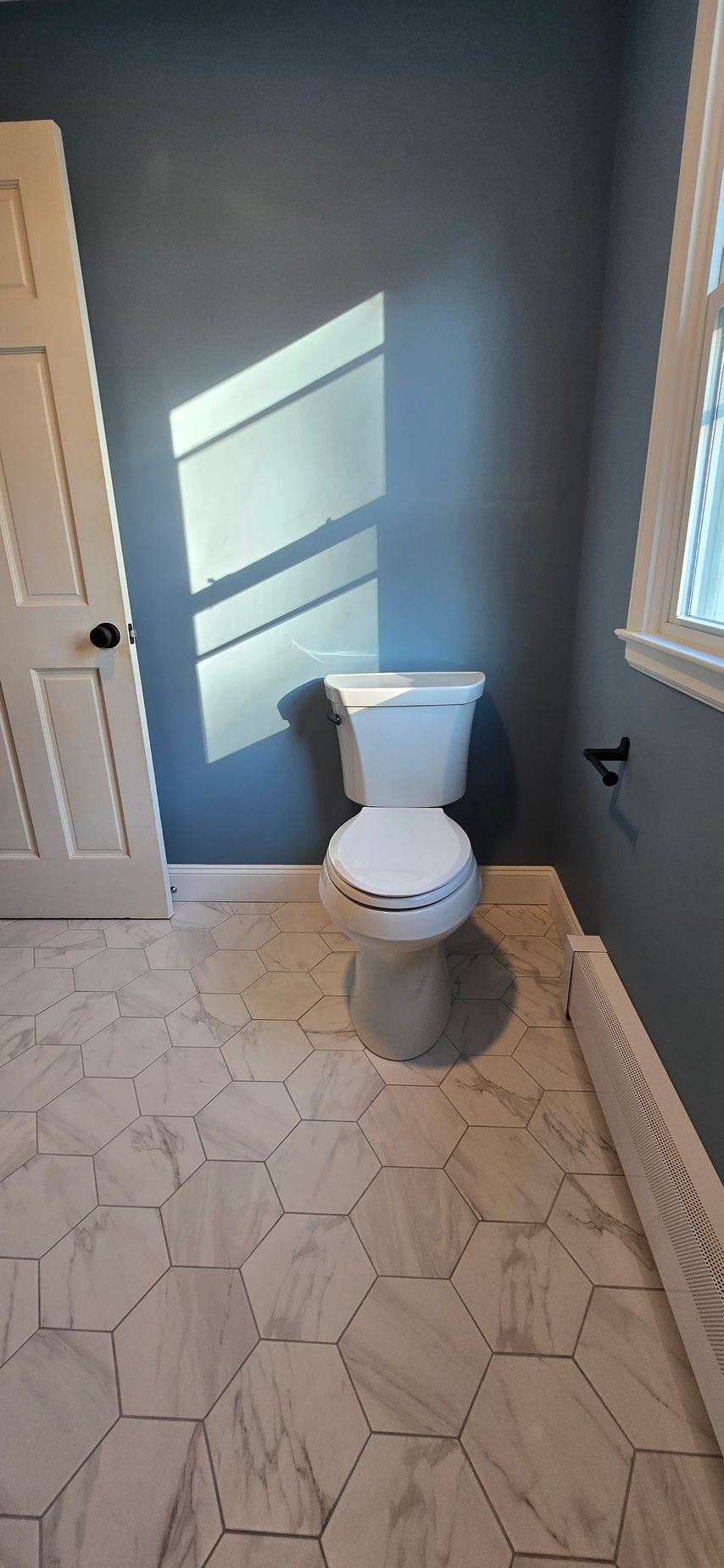 Bronze floor-mounted faucet with handheld shower head; lever and knob controls.
