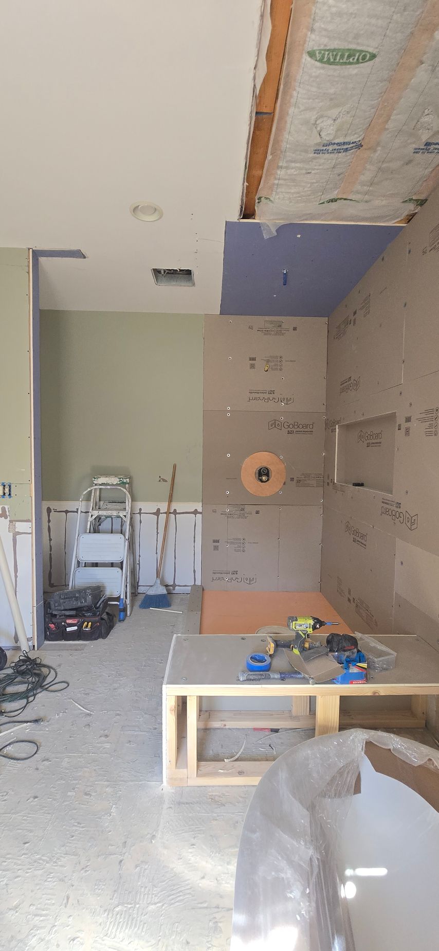 Partially finished room with drywall, ladder, tools, and a ceiling access panel under construction. By First Choice Bathroom Remodeling done in Haddam, CT.