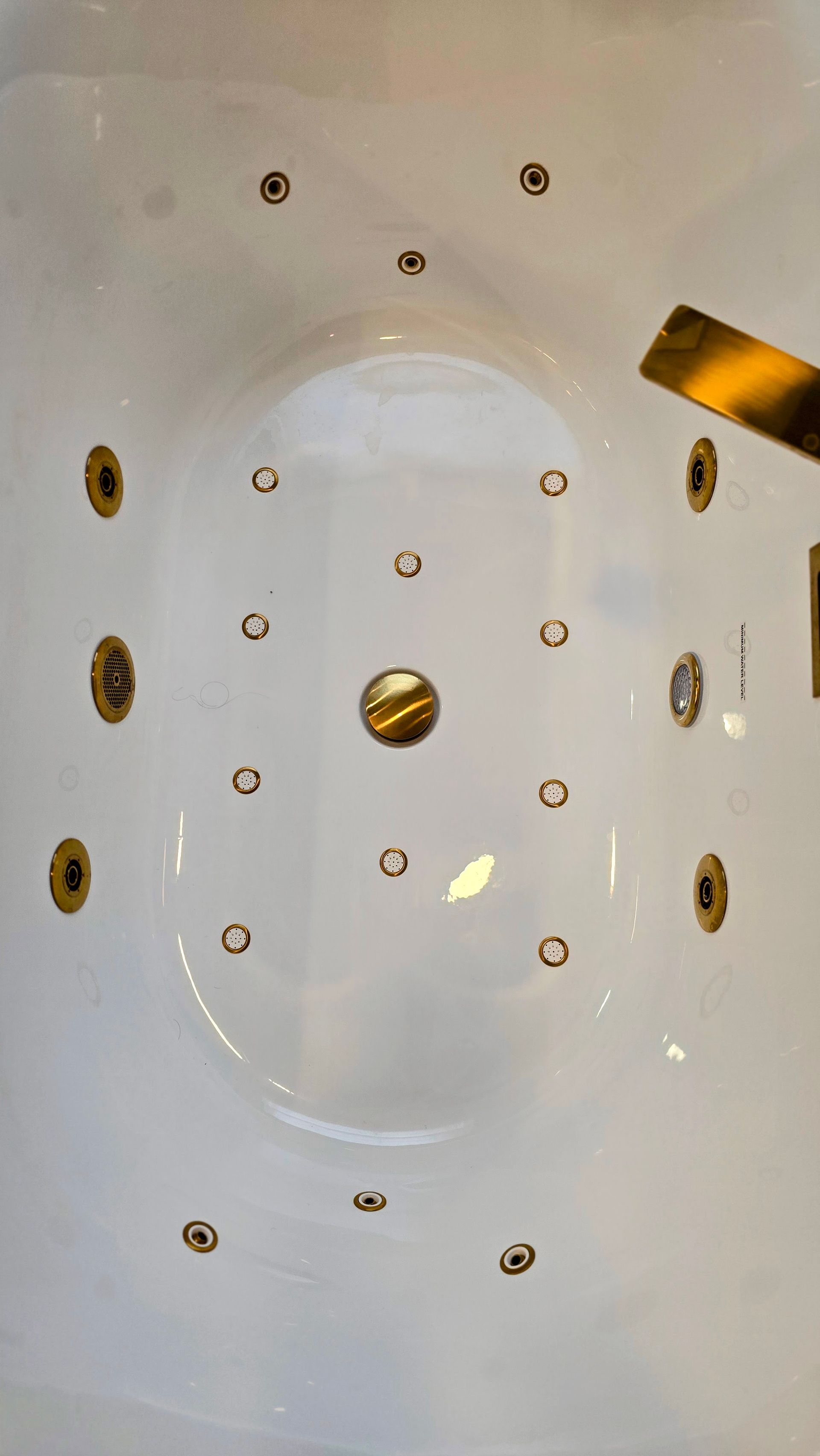 White bathtub with built-in jets and chrome fixtures, viewed from above.