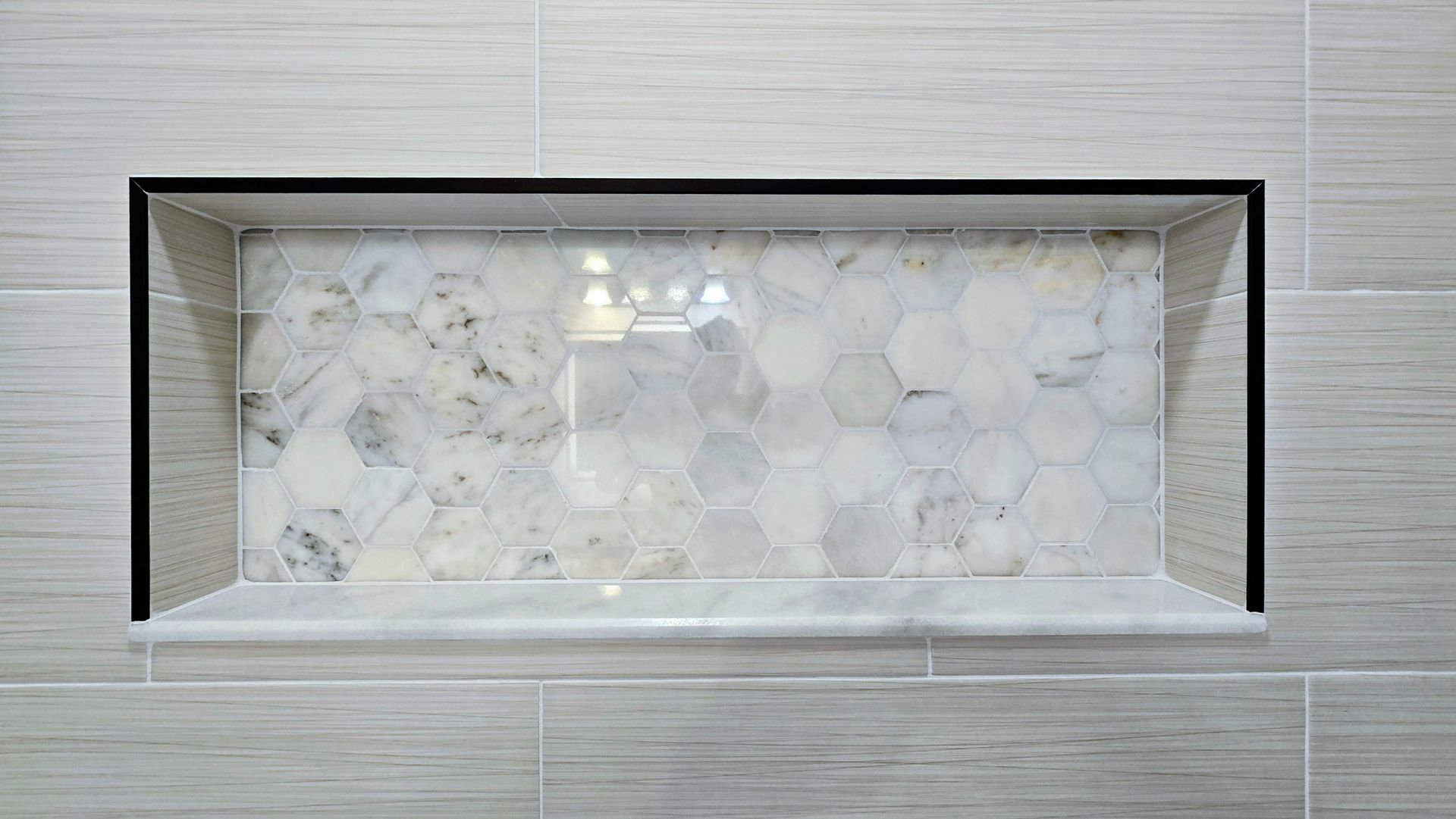 Built-in wall niche with frosted glass and white marble mosaic backdrop