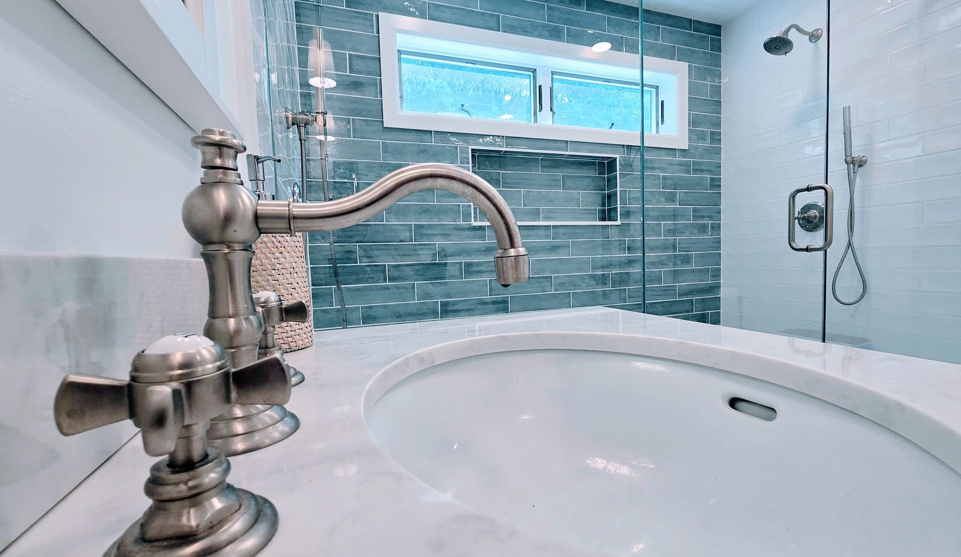 Modern bathroom remodel in Rocky Hill, CT completed by First Choice Bathroom Remodeling with gray and green tile wall, white tile floor, window, and chrome fixtures