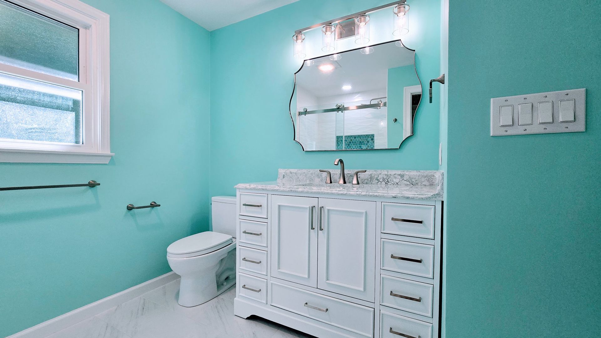 Turquoise bathroom with a white vanity, granite countertop, and decorative mirror lights. Southbury CT