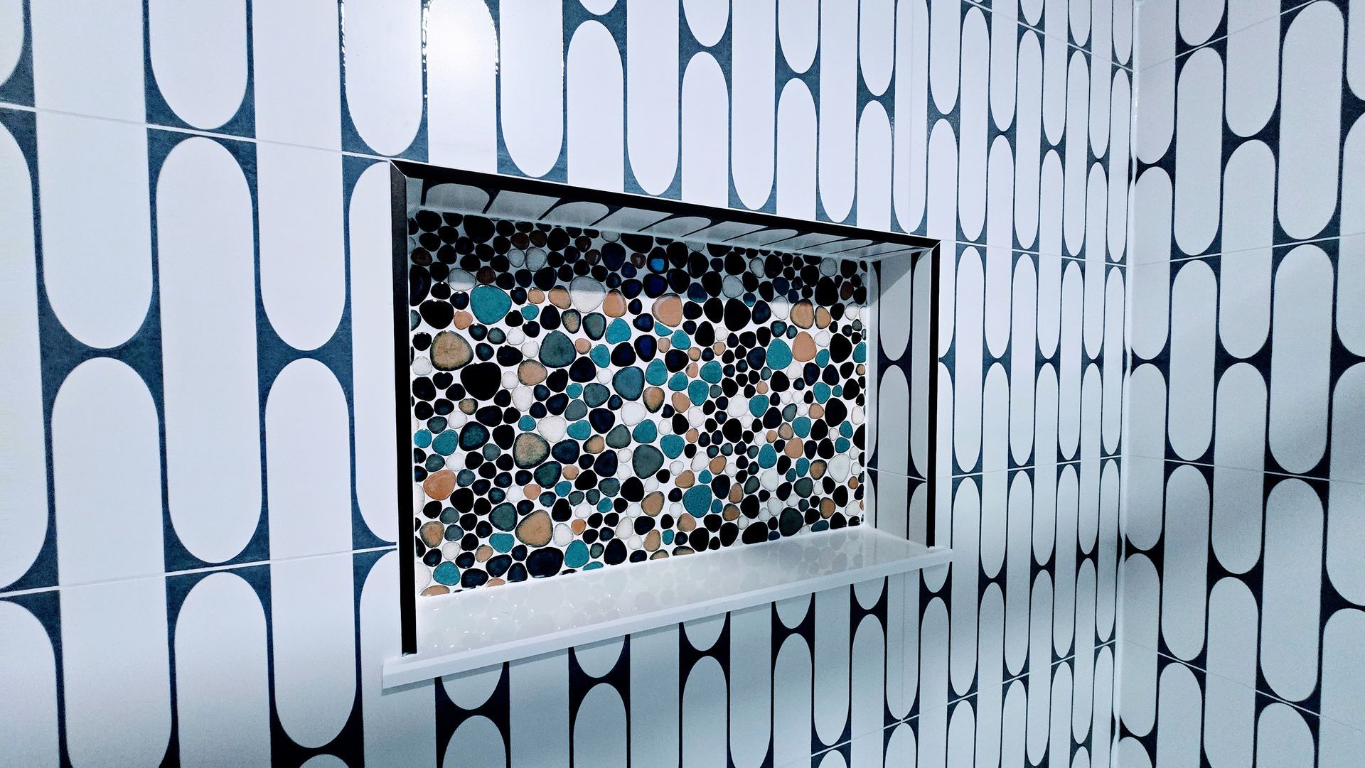 Blue-and-white patterned wall with a small mosaic-tiled recessed window.  By First Choice Bathroom Remodeling done in Bristol, CT.