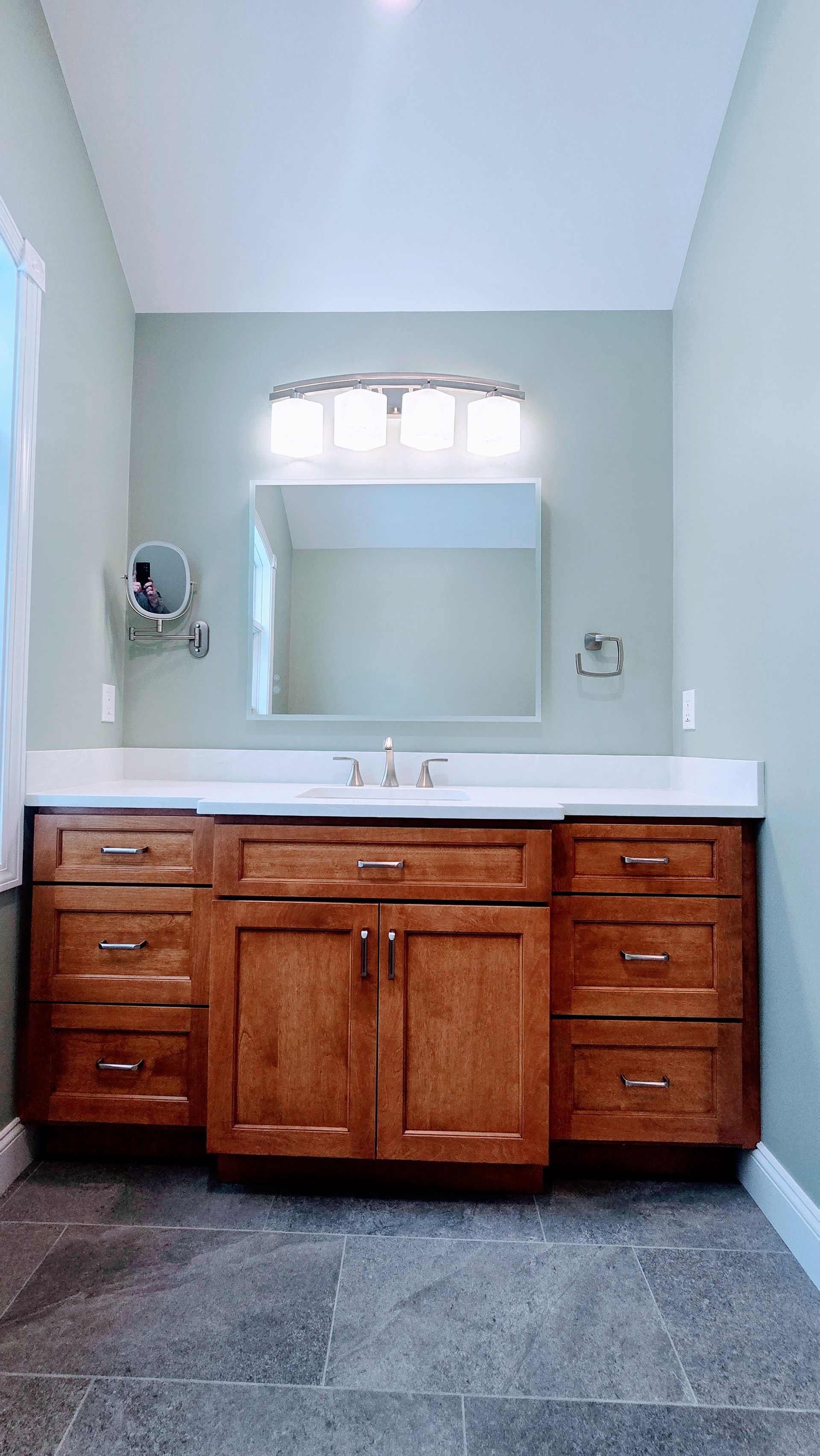 Bathroom with brown vanity in Glastonbury, CT, white countertop, and gray tiled floor.