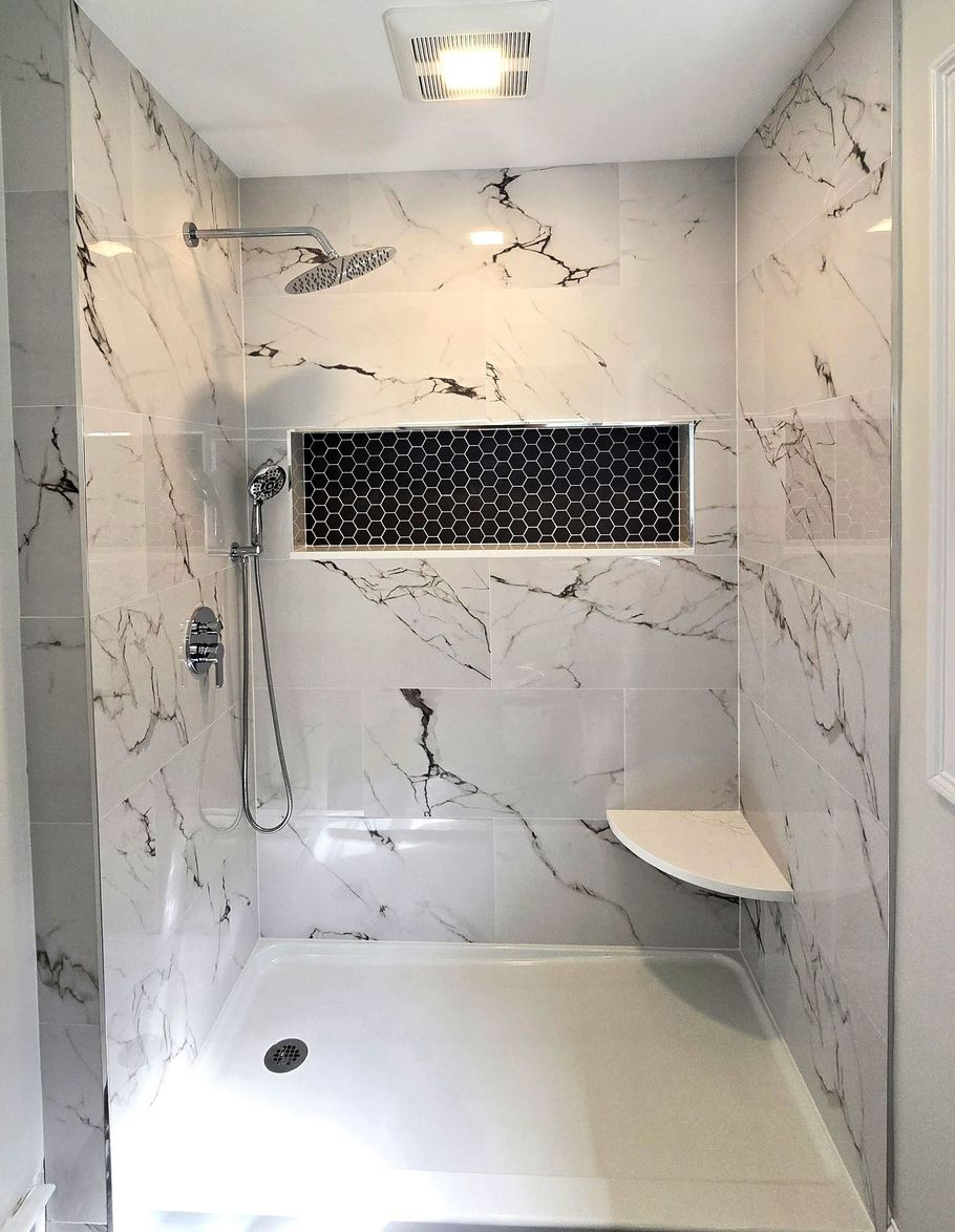 A bathroom with marble tiles and a walk in shower