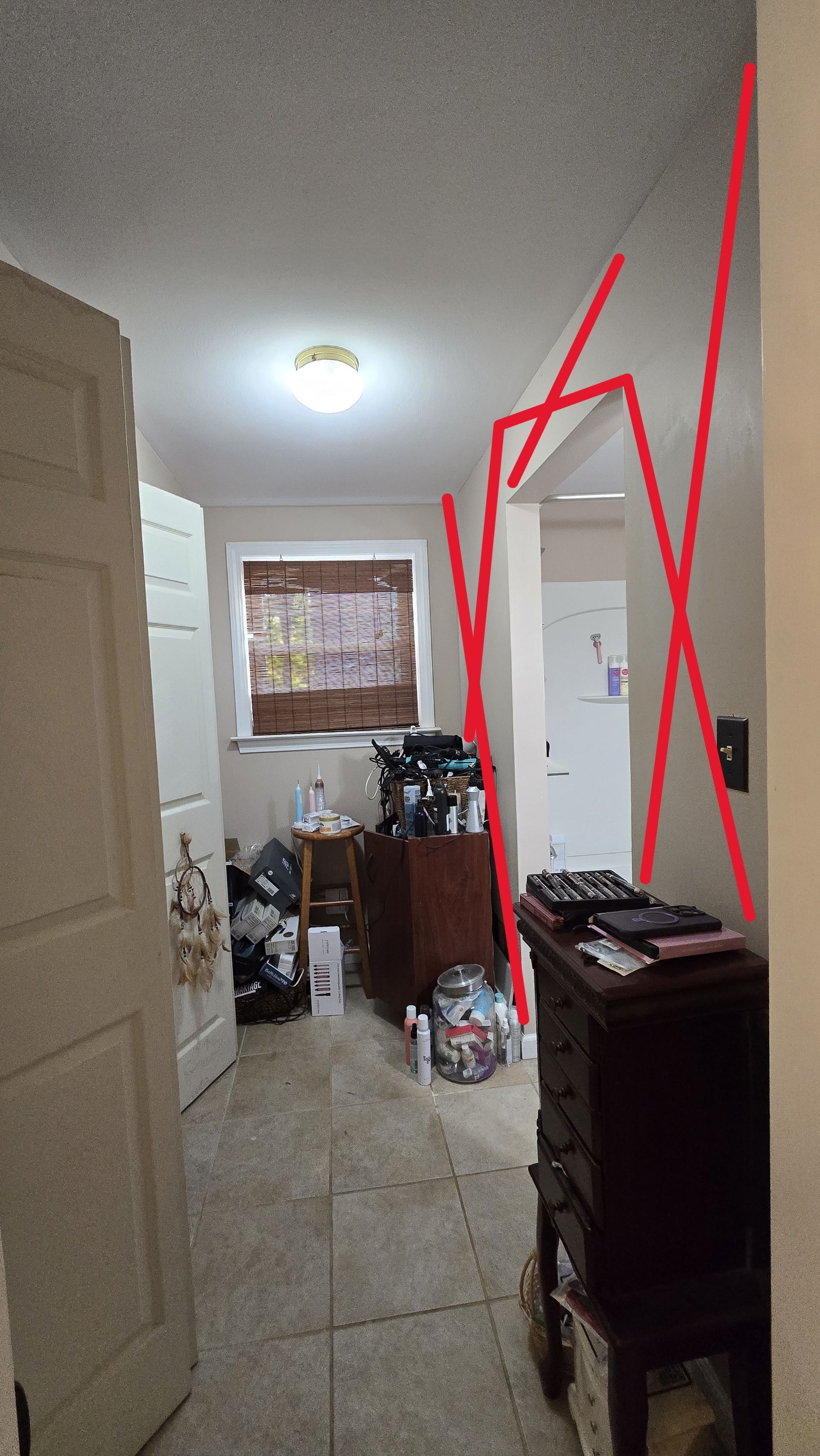 Narrow hallway with tiled floor in Southington, CT, ceiling light, mirror at end, and cluttered furniture along the walls.