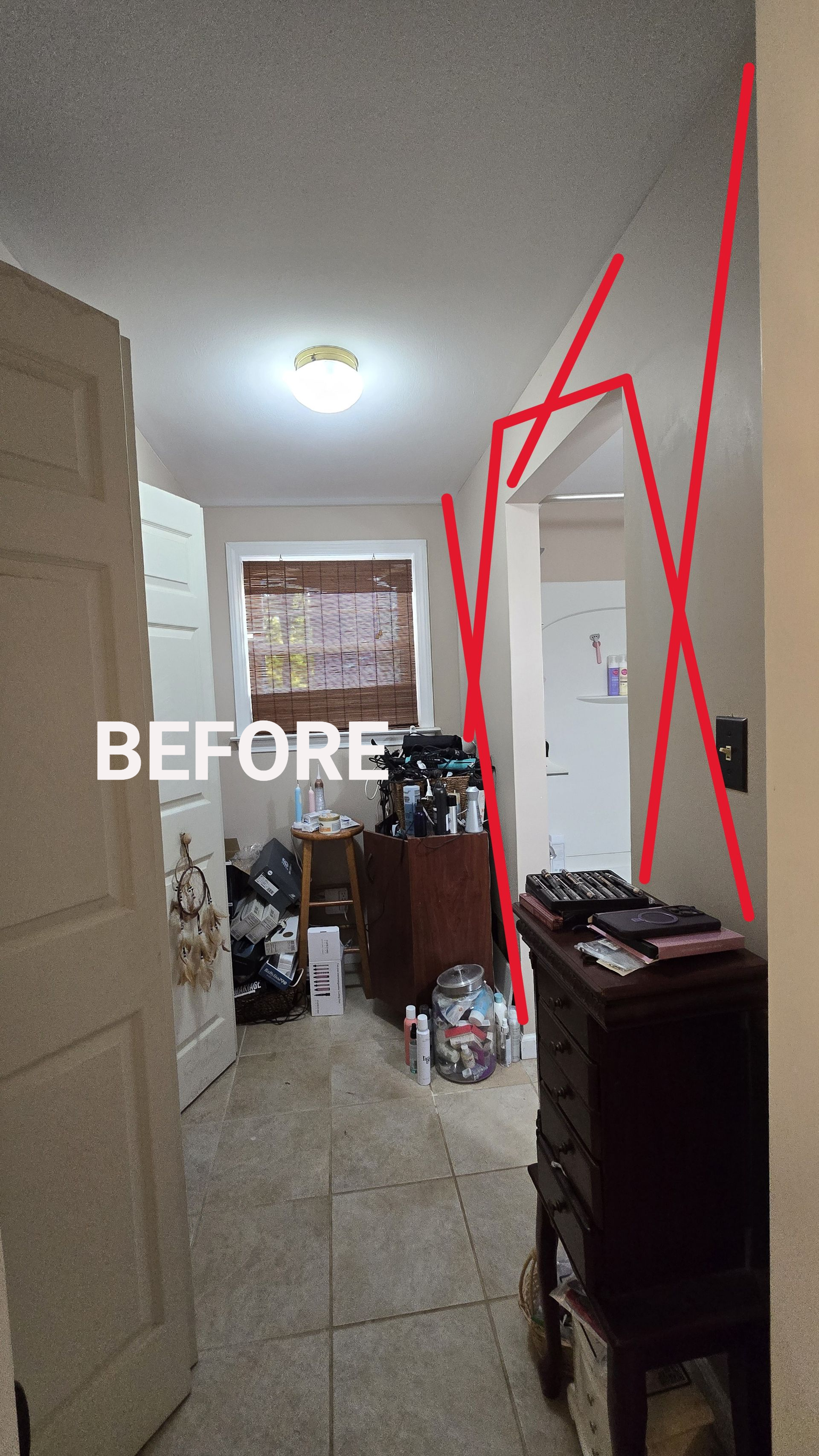 Narrow hallway with tiled floor, ceiling light, cluttered furniture, and red markings over the right wall and doorway.