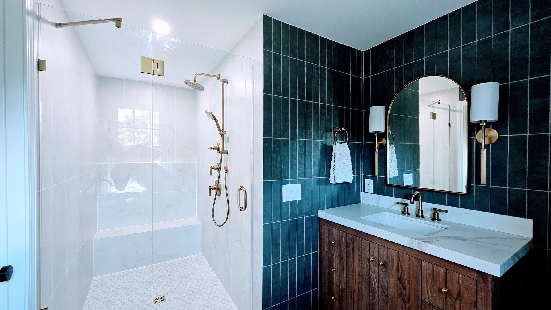 Modern bathroom with white shower, dark blue tile wall, vanity, and gold fixtures. By First Choice Bathroom Remodeling done in Glastonbury CT.