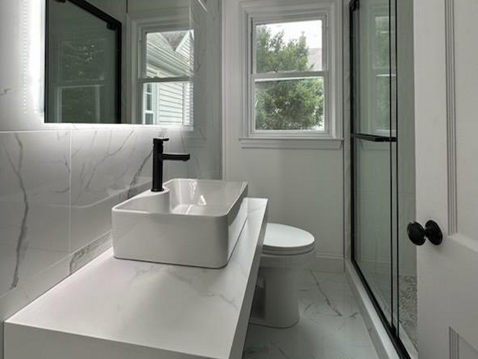 A bathroom with a sink , toilet and shower.