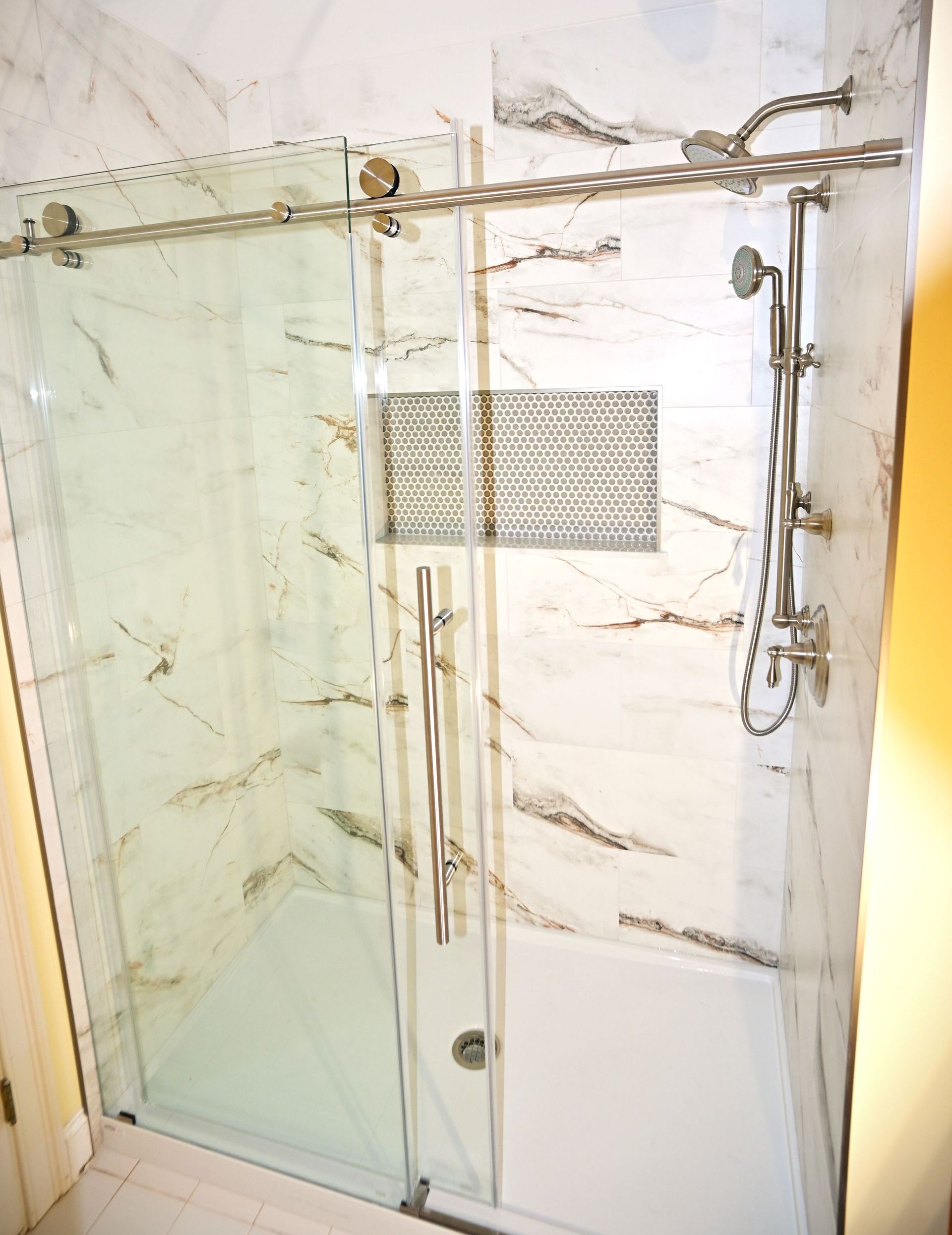 A bathroom with a sliding glass shower door
