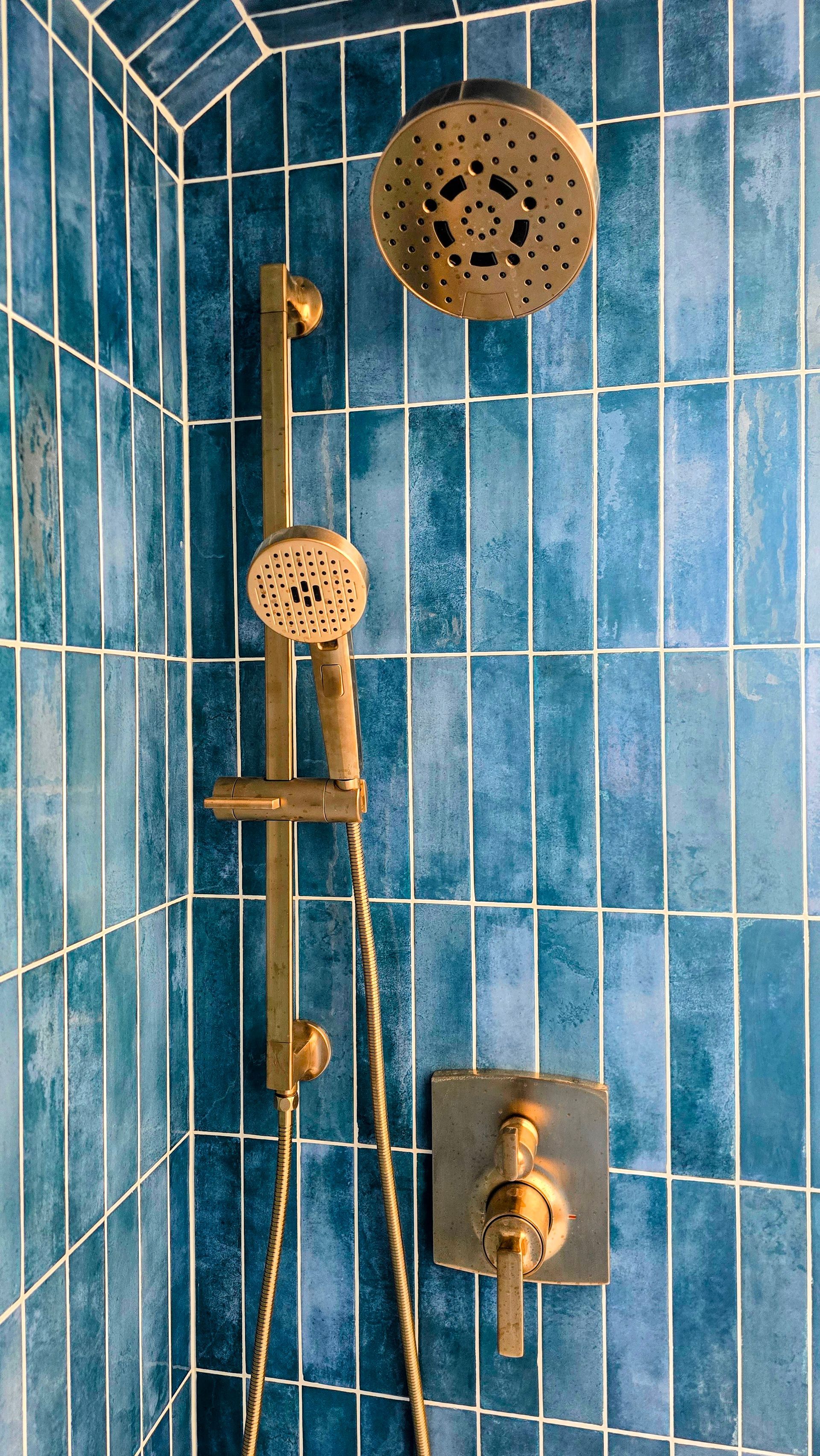 Gold shower fixtures against blue tile in Cromwell, CT