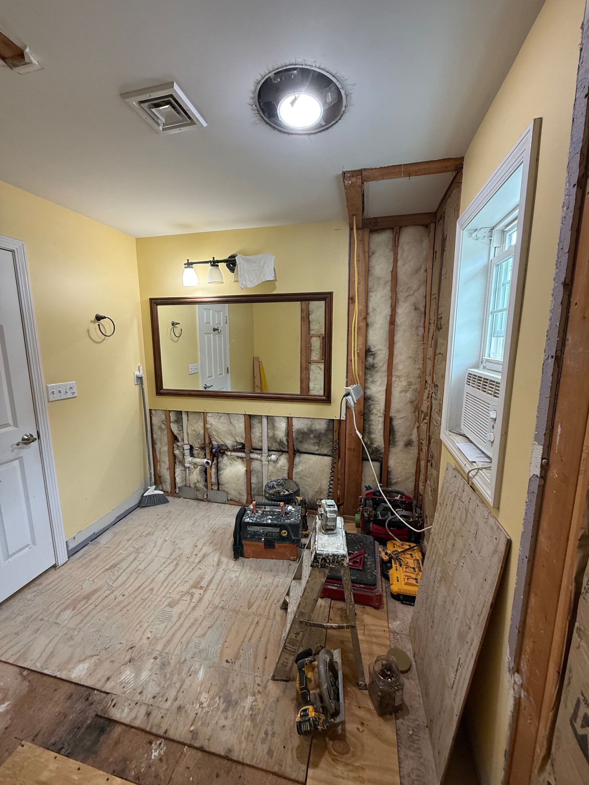A room that is being remodeled with a large mirror on the wall.