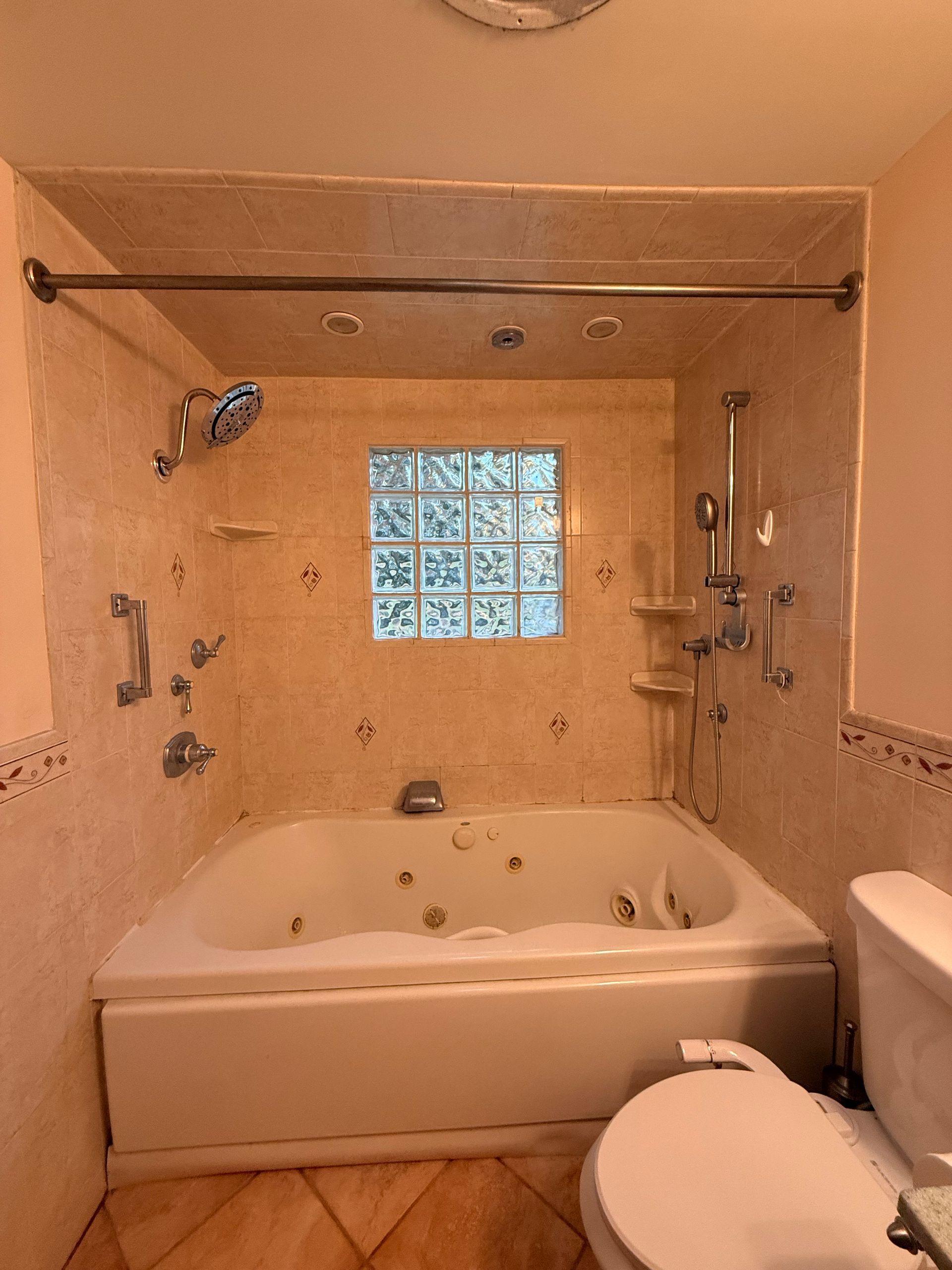 Small West Hartford bathroom with toilet, shower, sink, white walls, wood ceiling.