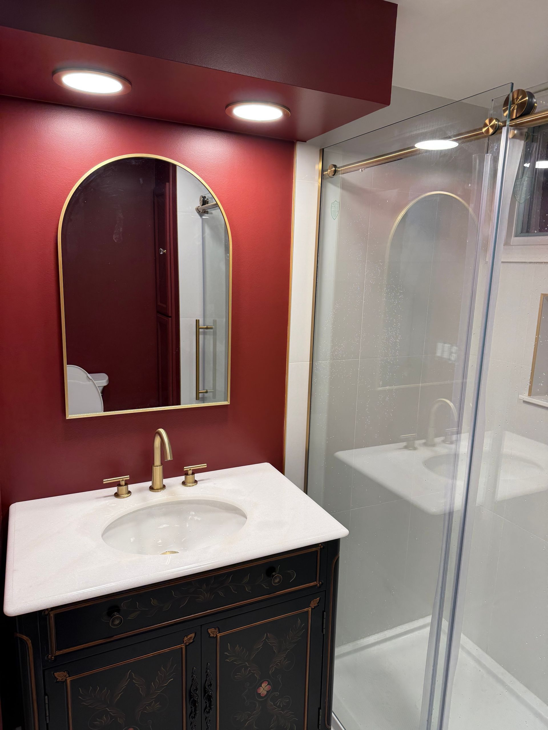 A bathroom with a sink a mirror and a walk in shower