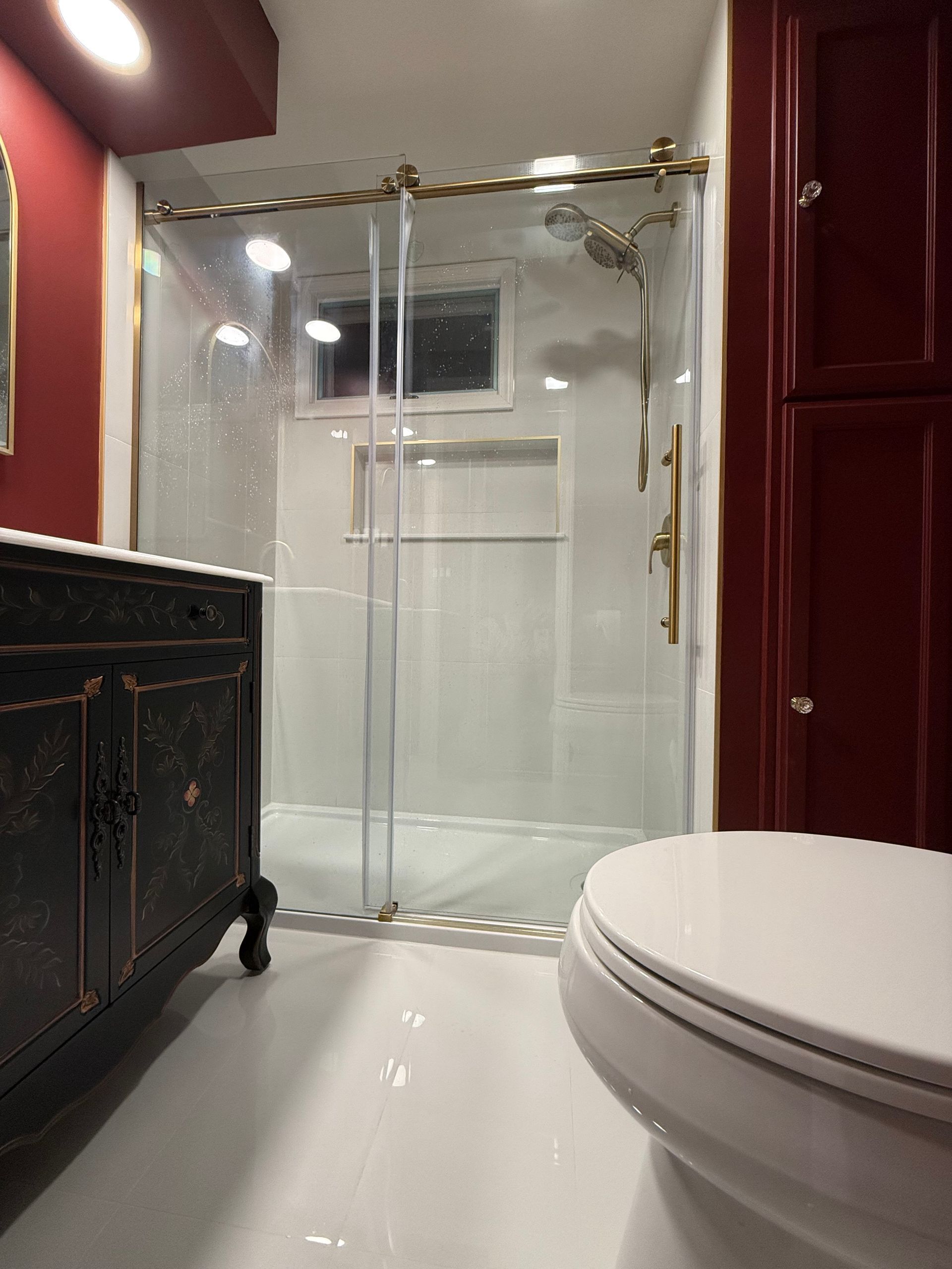 A bathroom with a toilet and a shower stall