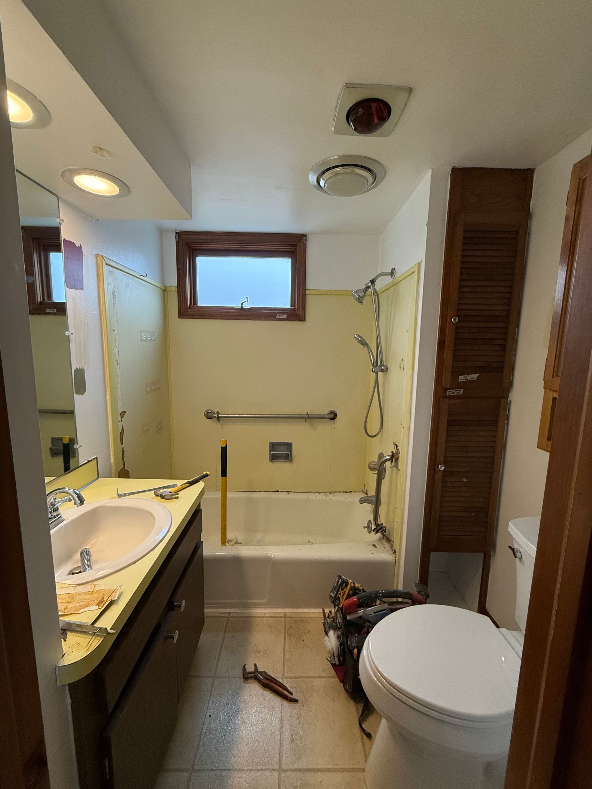 A bathroom with a toilet , sink , tub and shower.