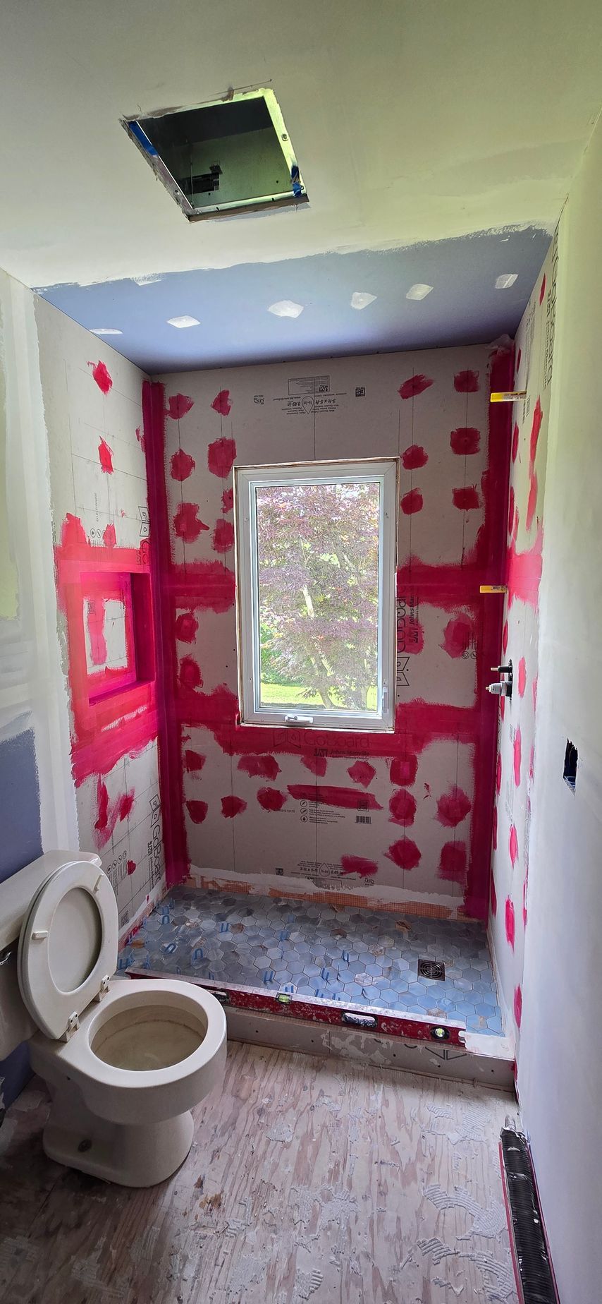 A yellow underfloor heating system is being installed in a bathroom.