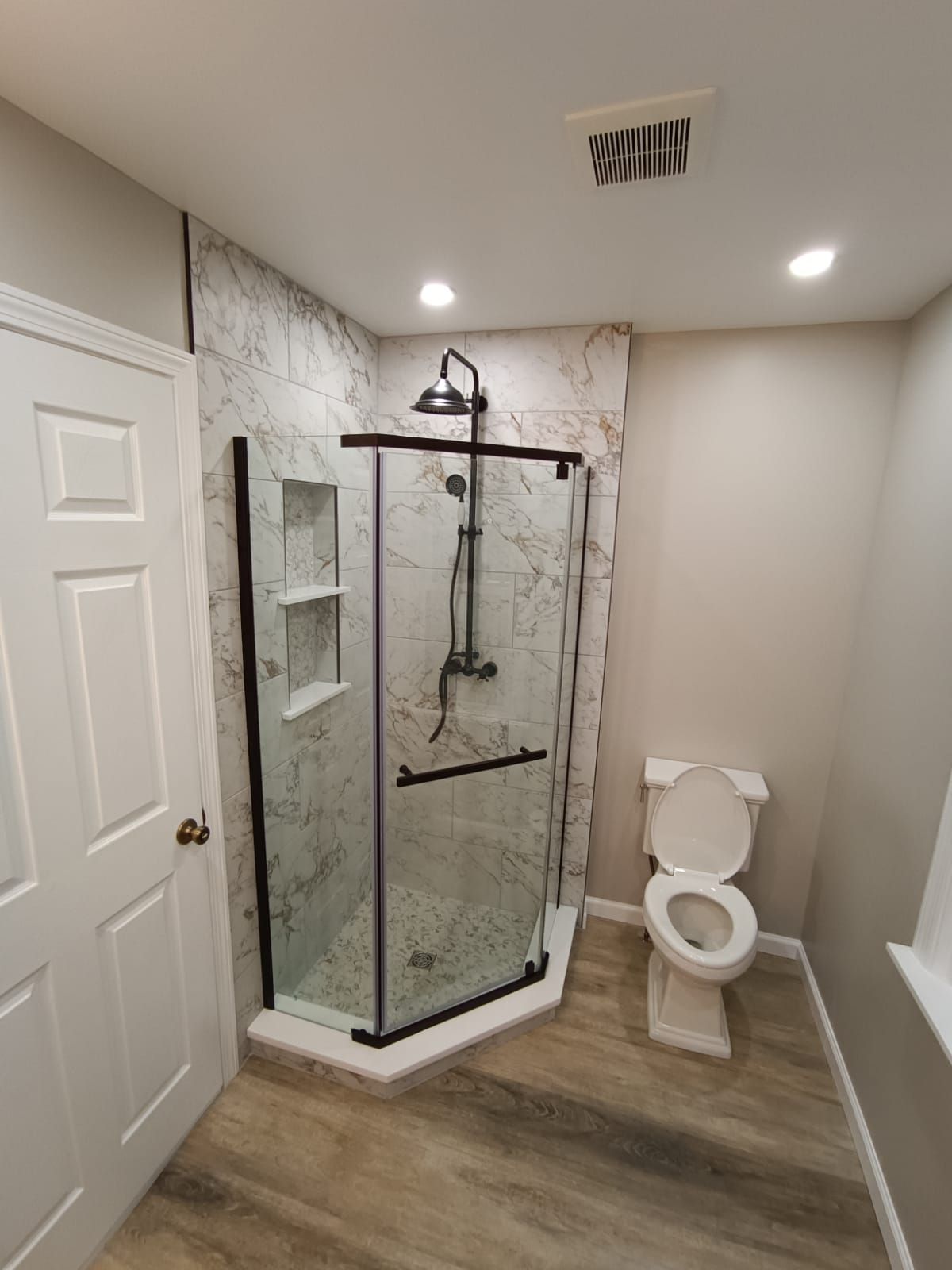 A bathroom with a toilet and a shower stall.