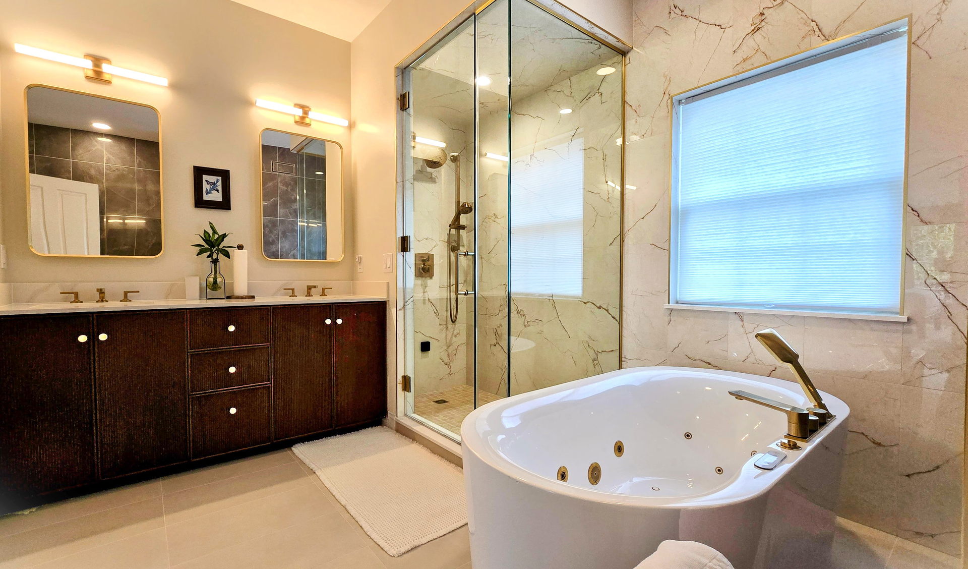 Modern bathroom in Cromwell, CT 
with double vanity, glass shower, and white soaking tub near a window.