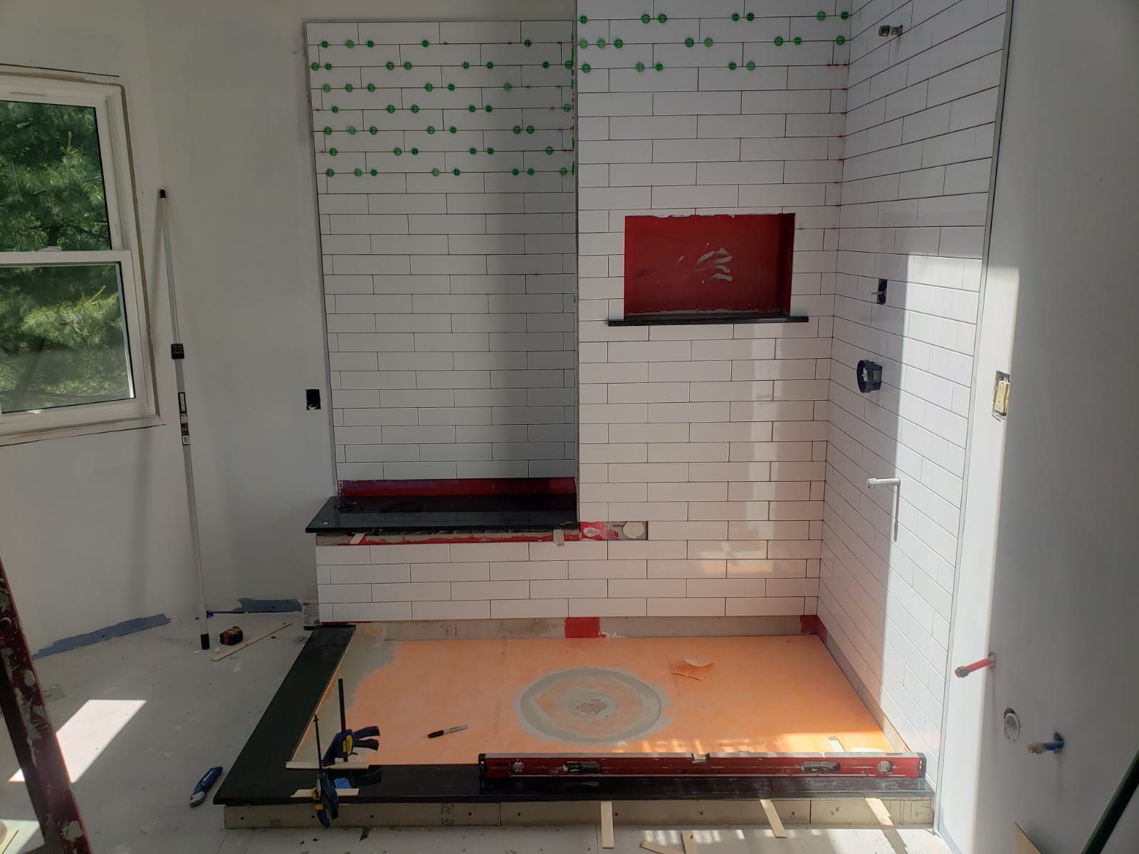 A bathroom that is being remodeled with white tiles