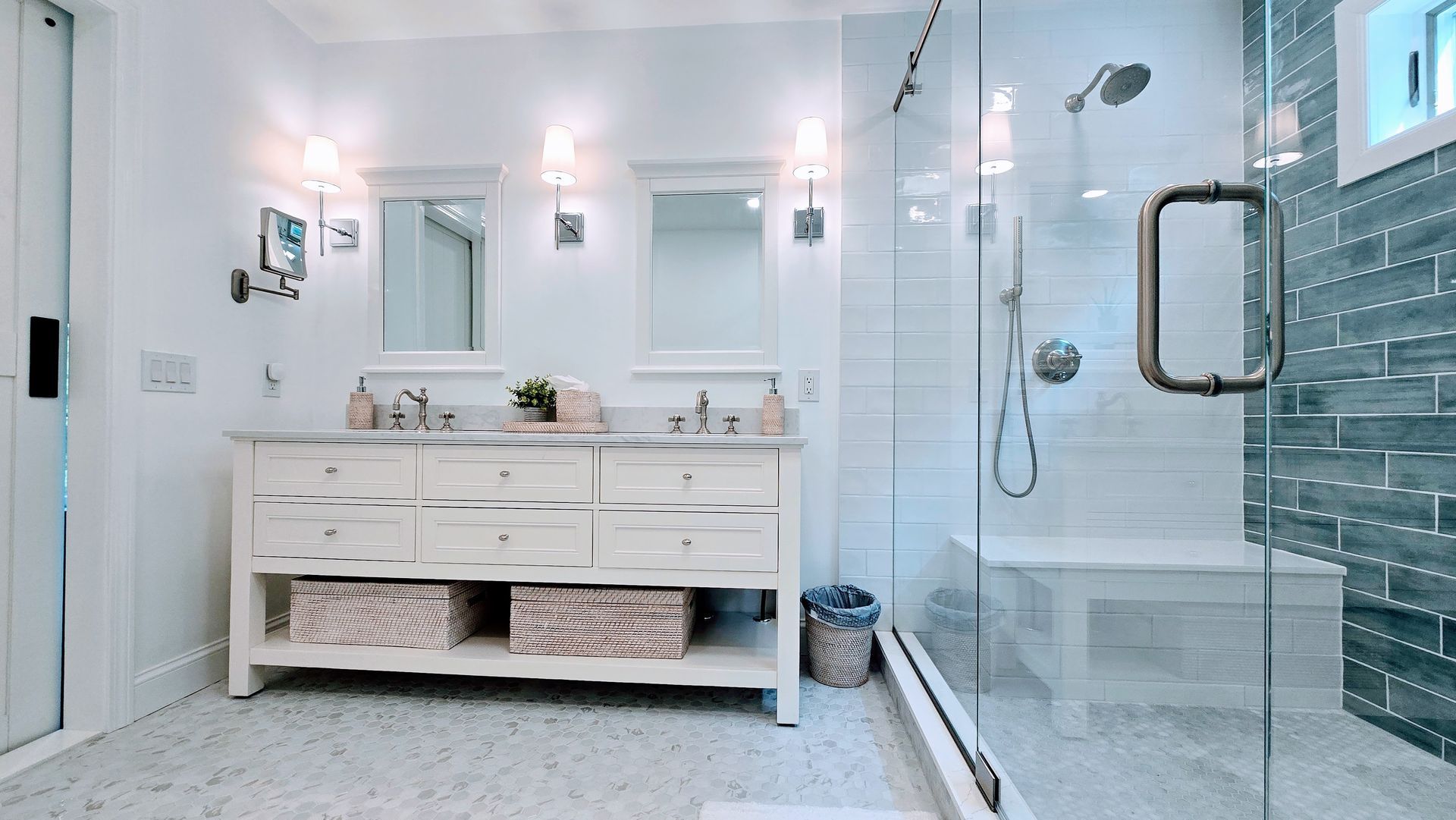 Bright modern bathroom in Rocky Hill, CT with white vanity, double sinks, glass shower, and tiled walls