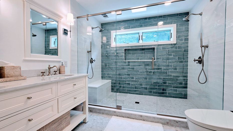 Bright modern bathroom in Rocky Hill, CT with double vanity, walk-in shower, blue tile accent wall, and freestanding tub.
