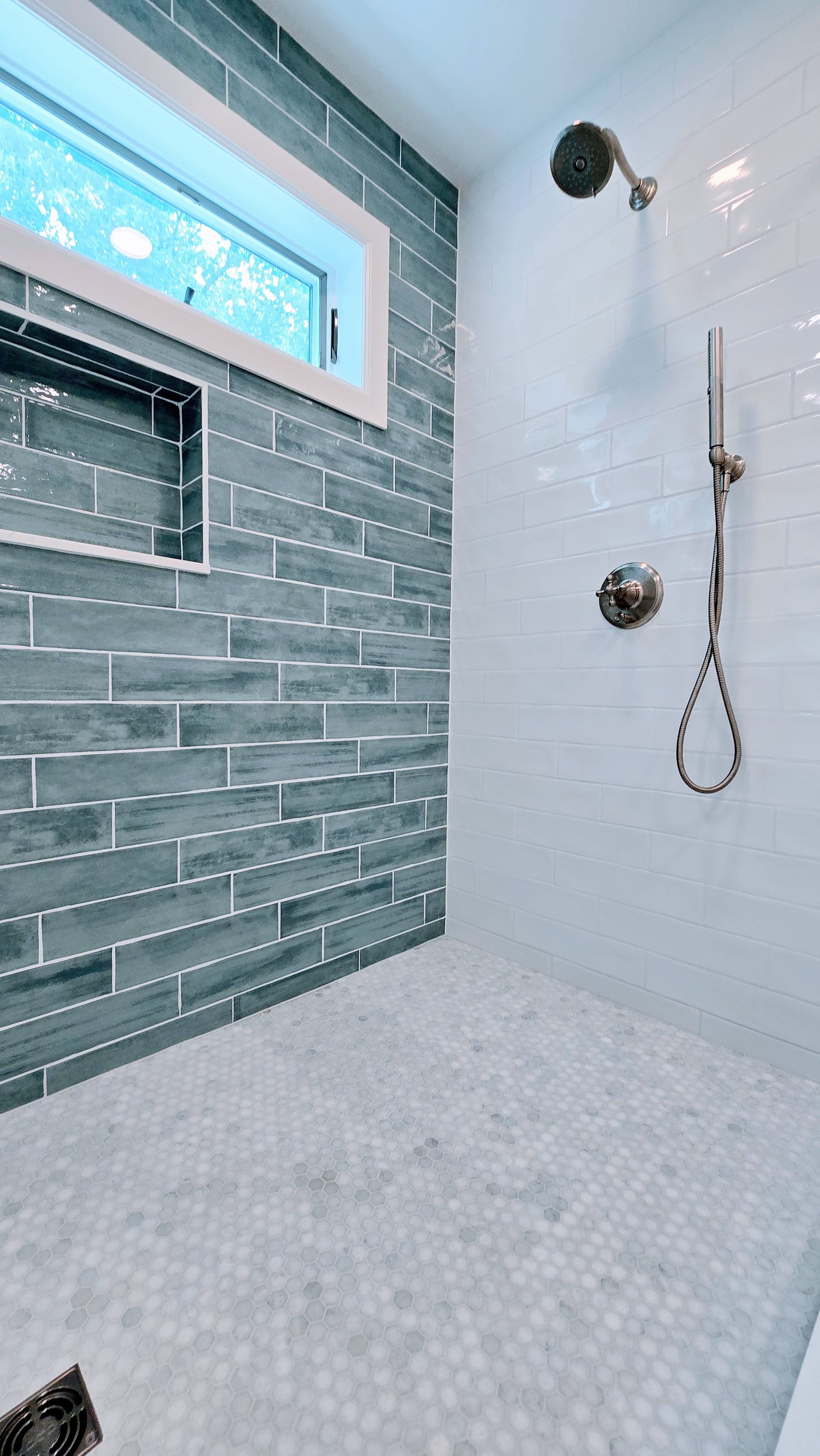 Modern bathroom remodel in Rocky Hill, CT completed by First Choice Bathroom Remodeling with gray and green tile wall, white tile floor, window, and chrome fixtures