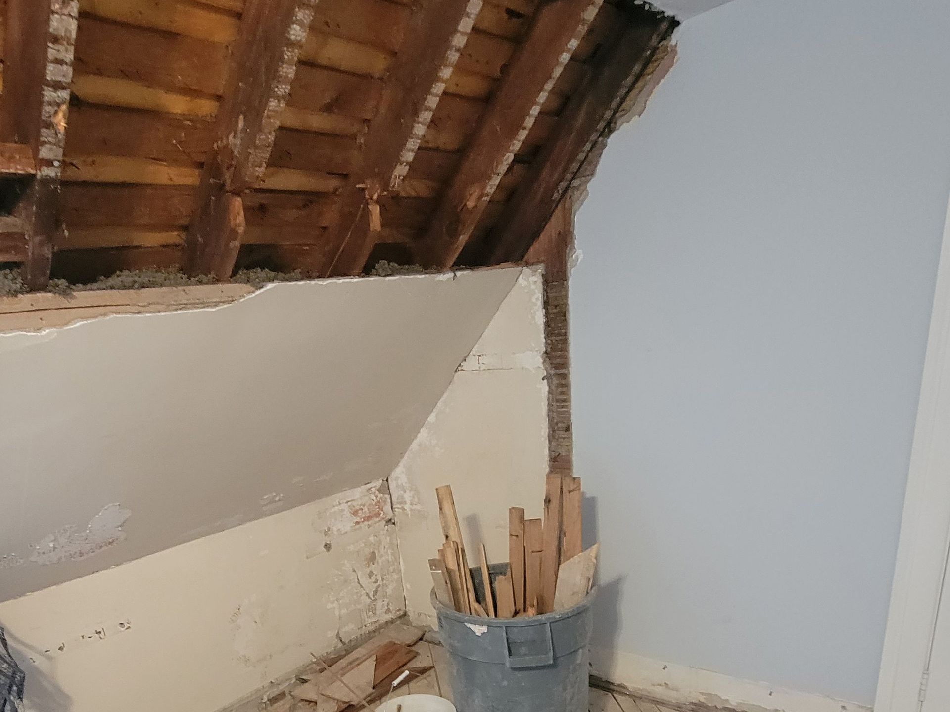 There is a bucket of wood in the corner of the room.