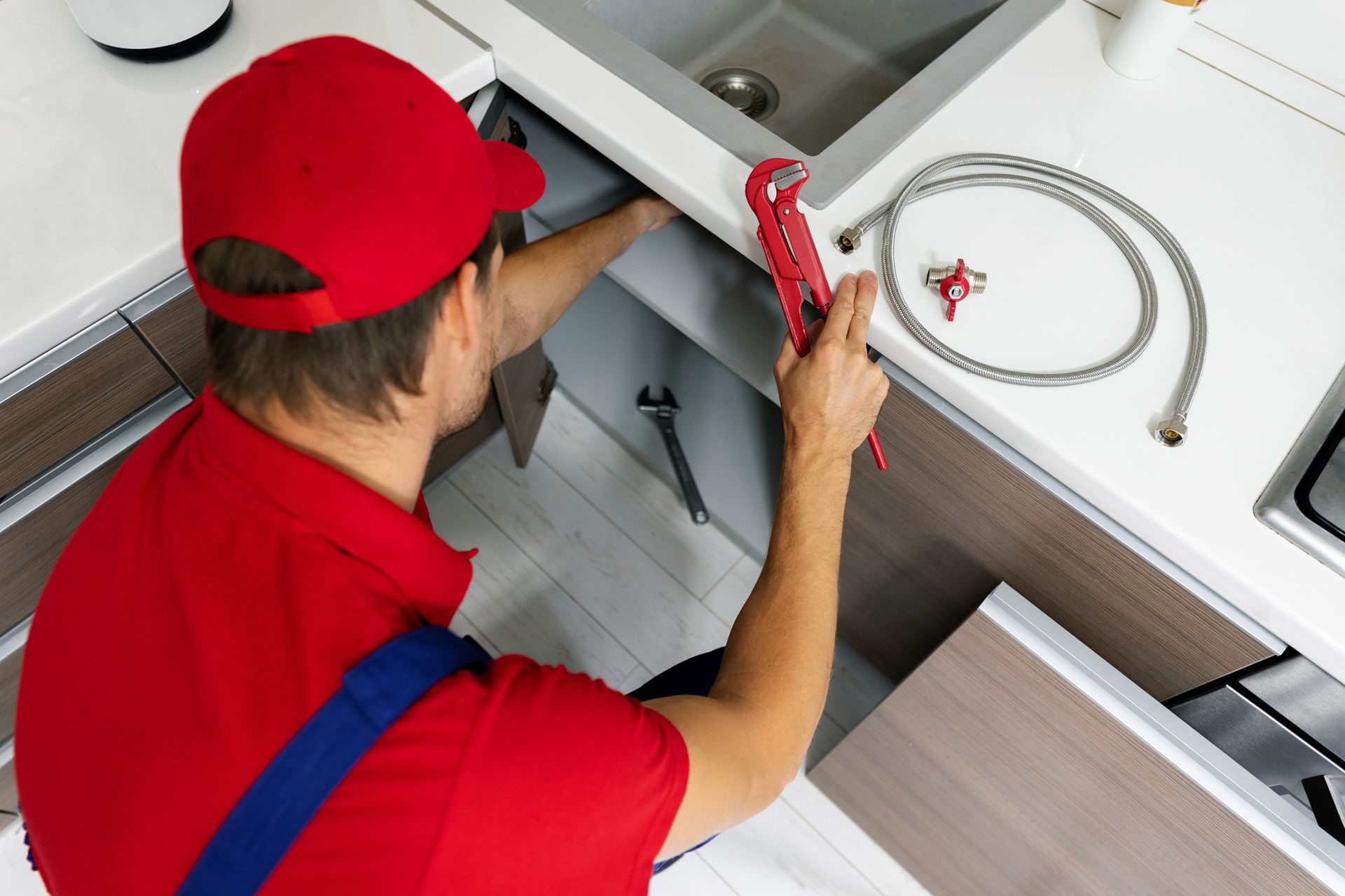 Plumber working under sink