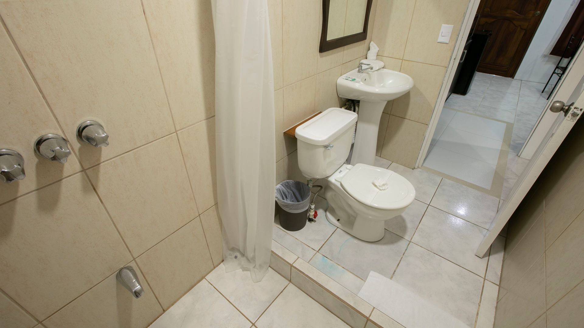 a bathroom with a toilet , sink and shower .
