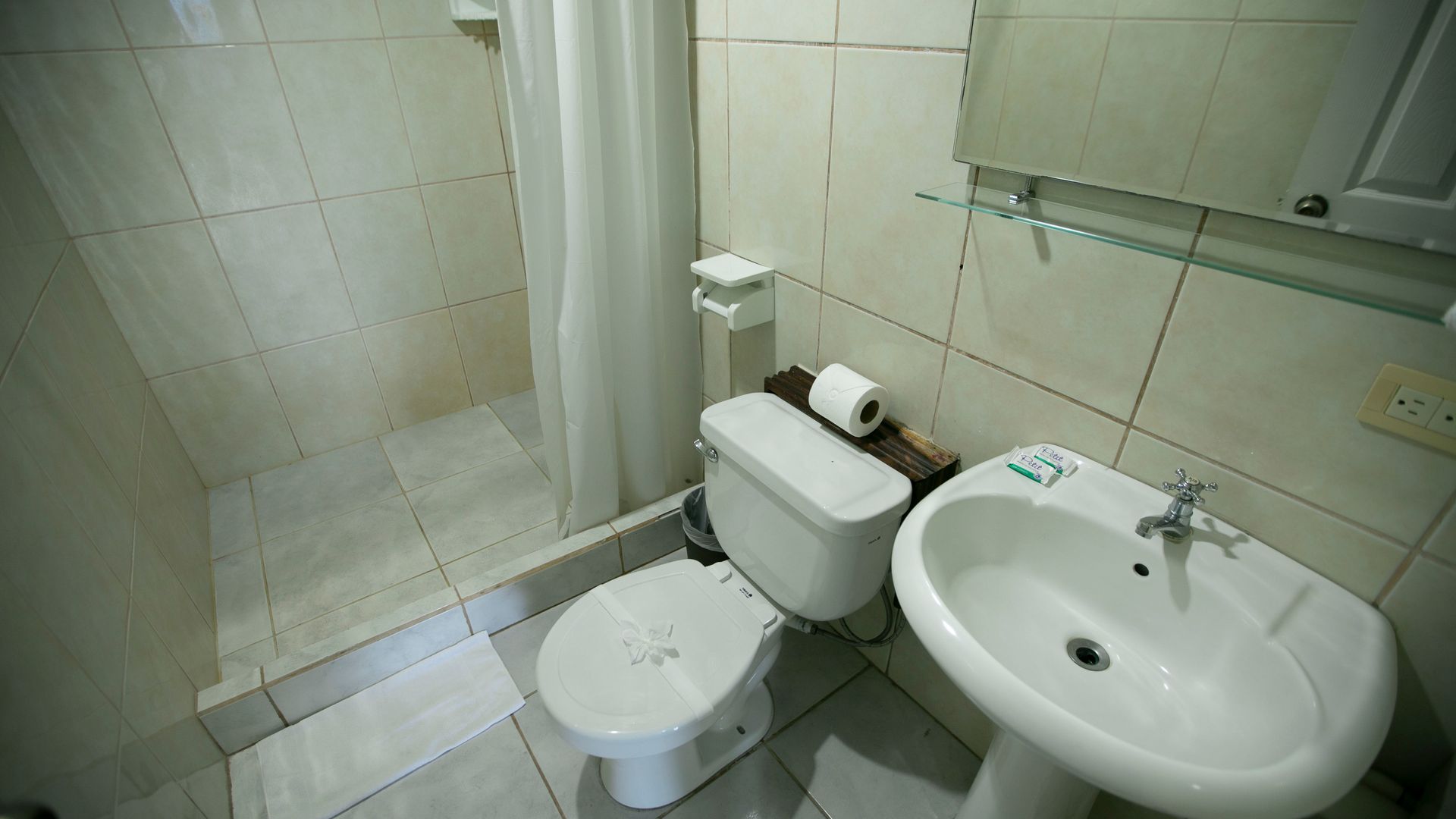 a bathroom with a toilet , sink and shower .