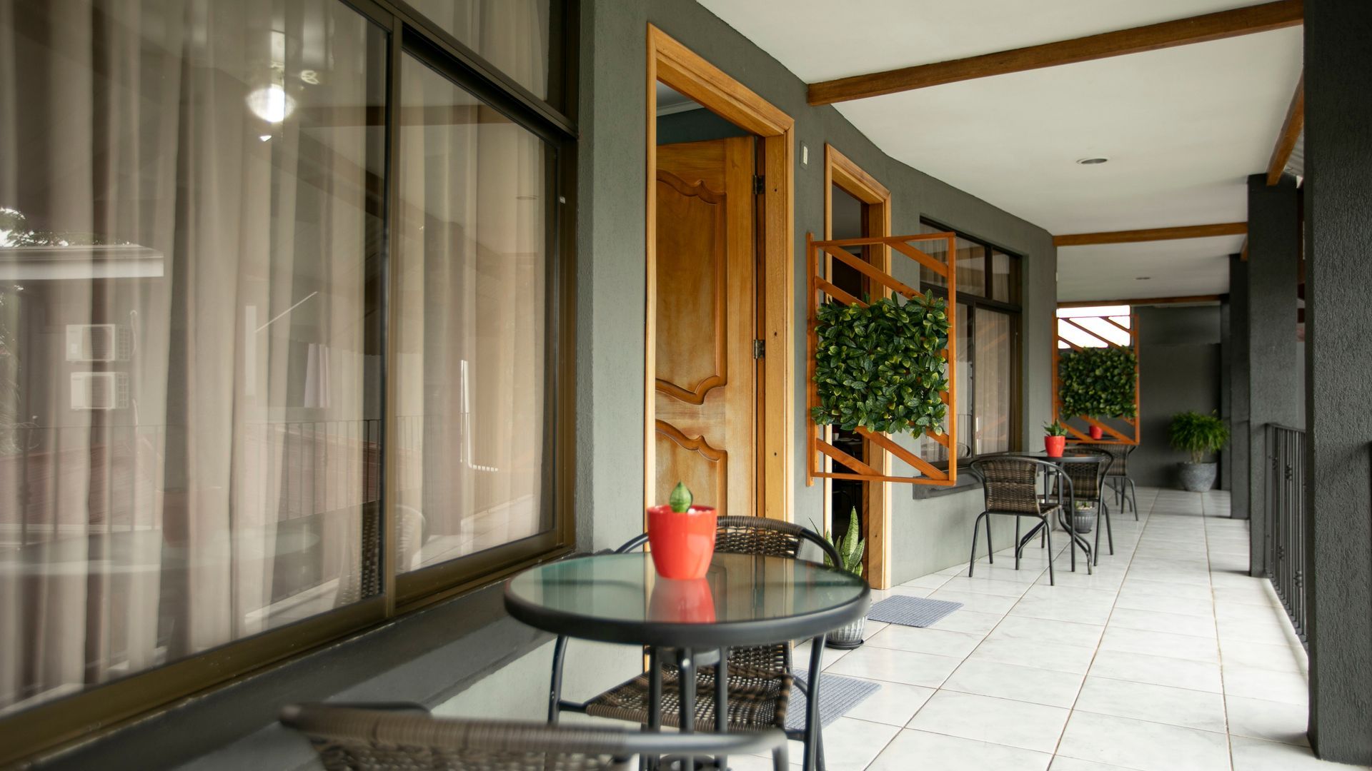 a balcony with a table and chairs and a potted plant on it