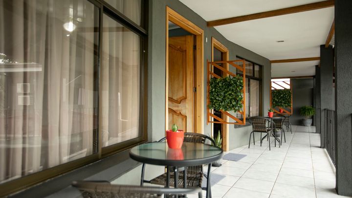 a balcony with a table and chairs and a potted plant on it