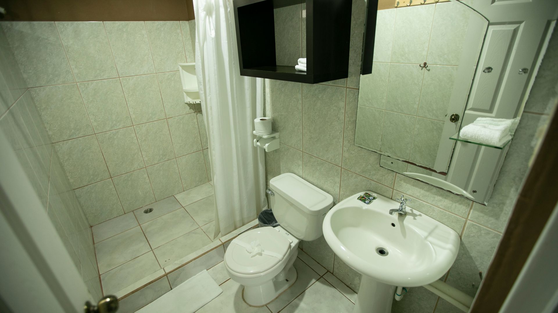 a bathroom with a toilet , sink and mirror .