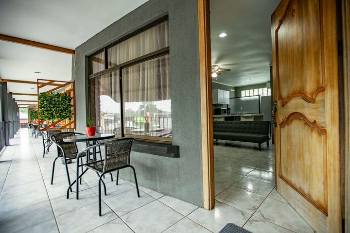 a balcony with a table and chairs in front of a building .