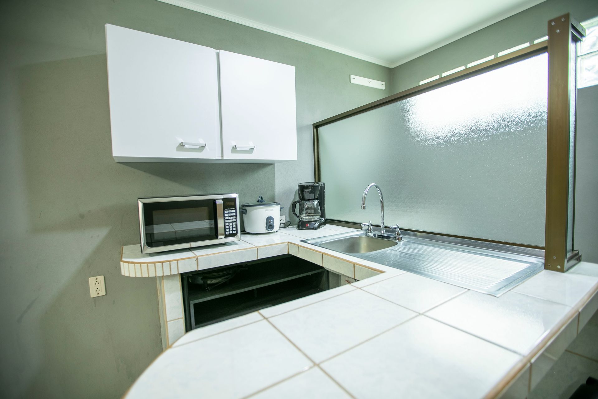 a kitchen with a sink , microwave , and coffee maker