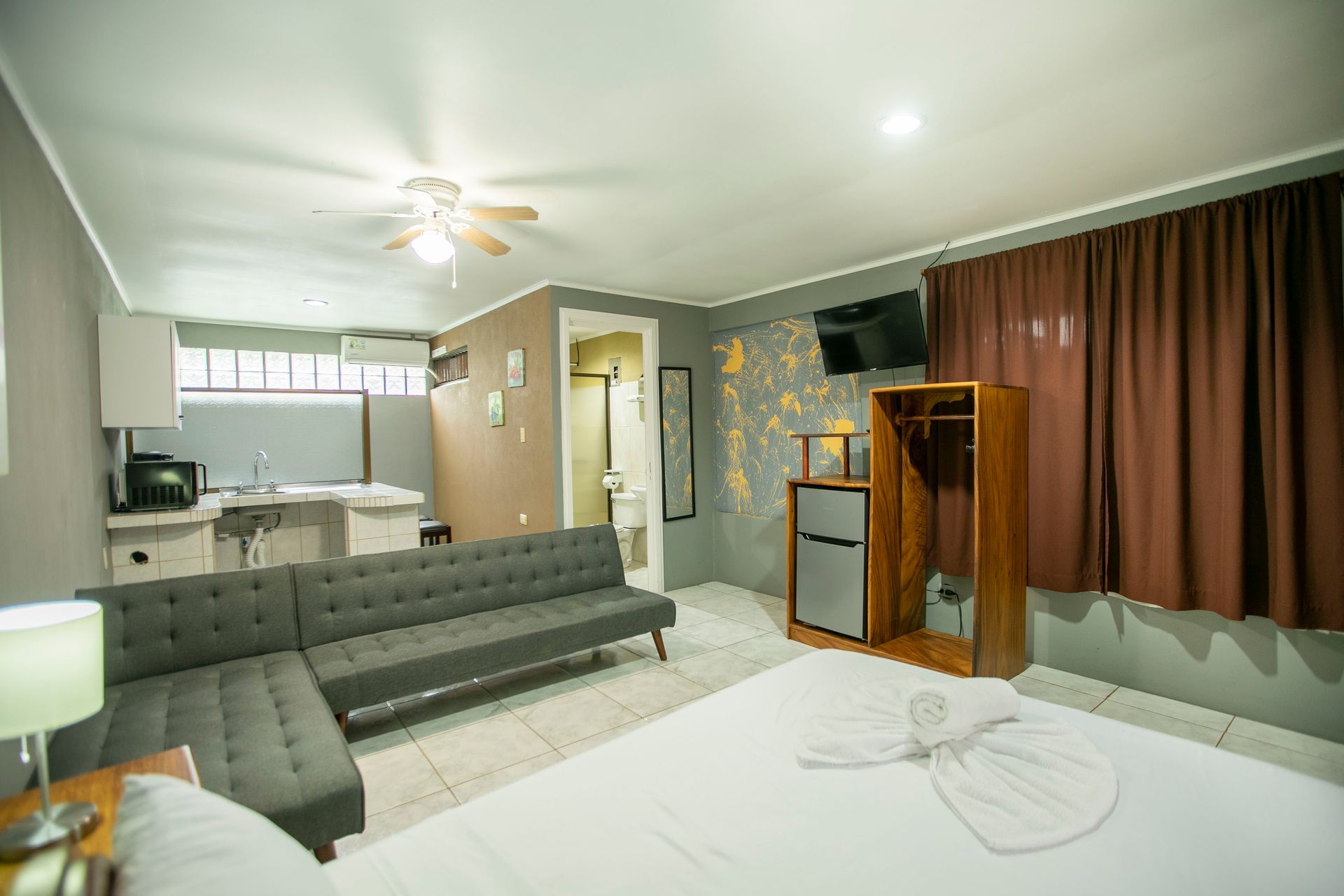 a hotel room with a bed , couch , and television .